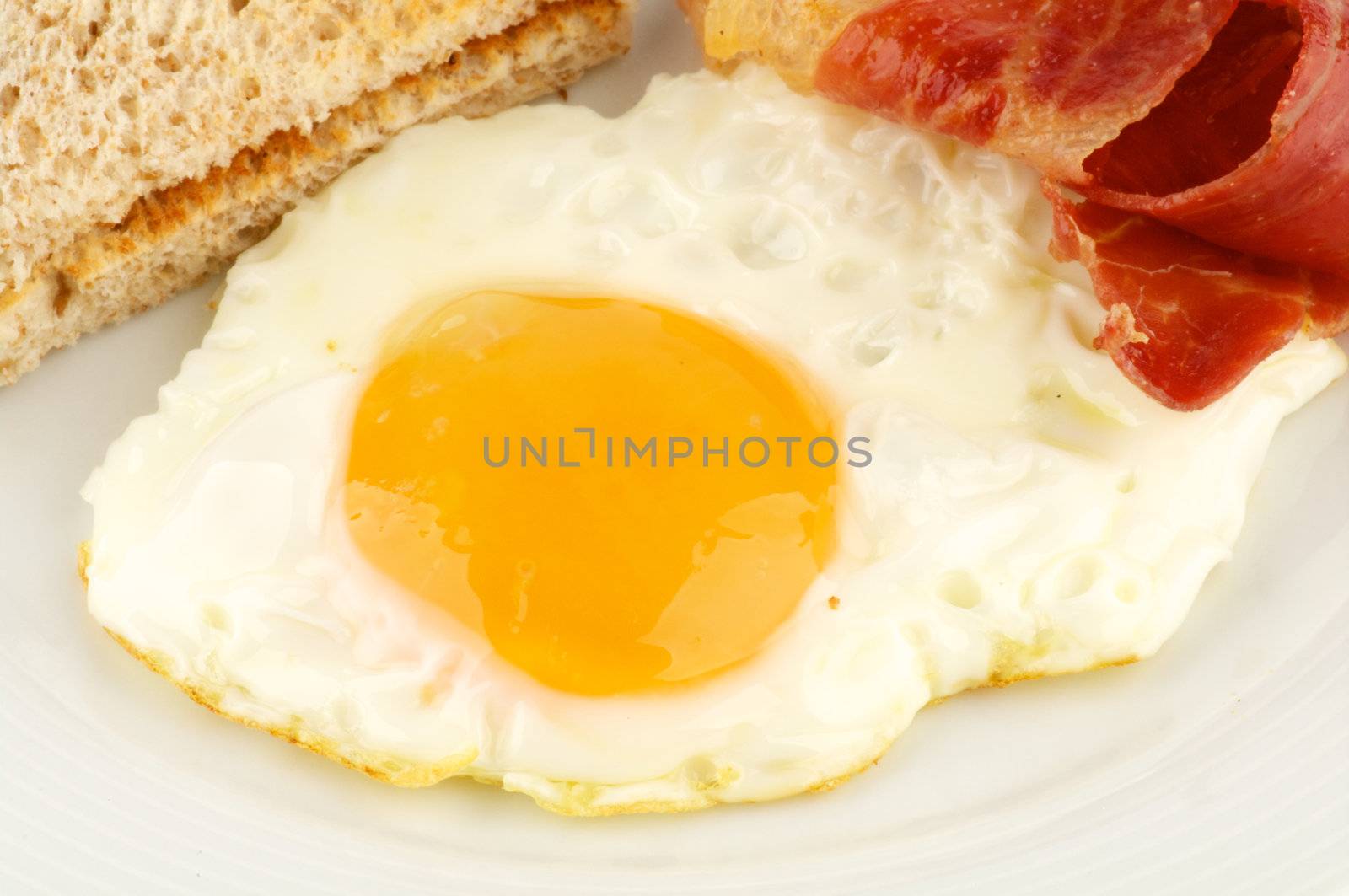 Bacon, eggs and toasts close up isolated on white background