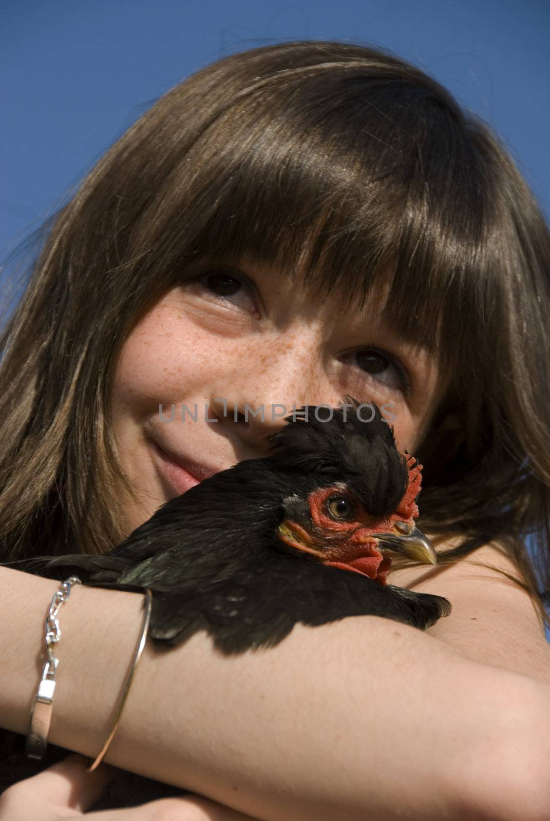 smiling girl and her little little black chicken in a farm
