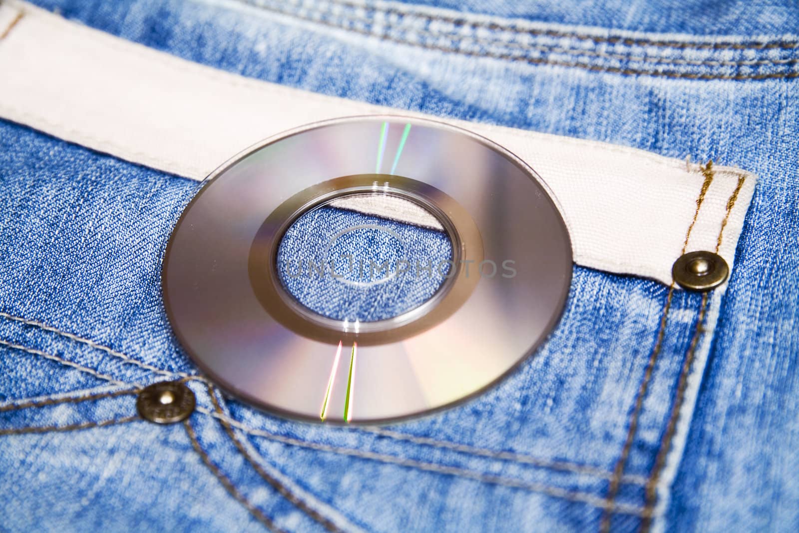 compact disk with modern music against fashionable blue jeans