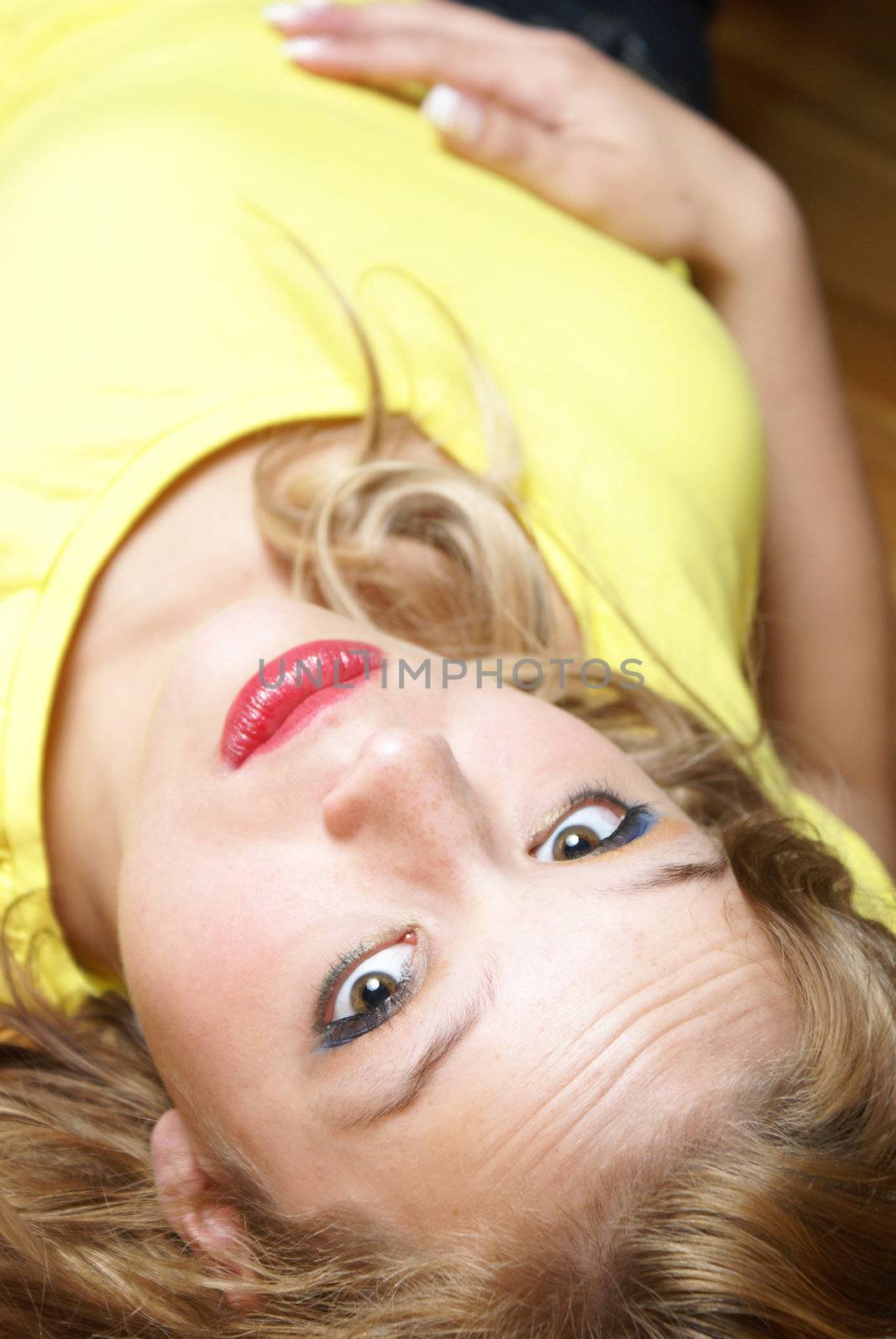 An attractive woman lays on her back while on the floor.