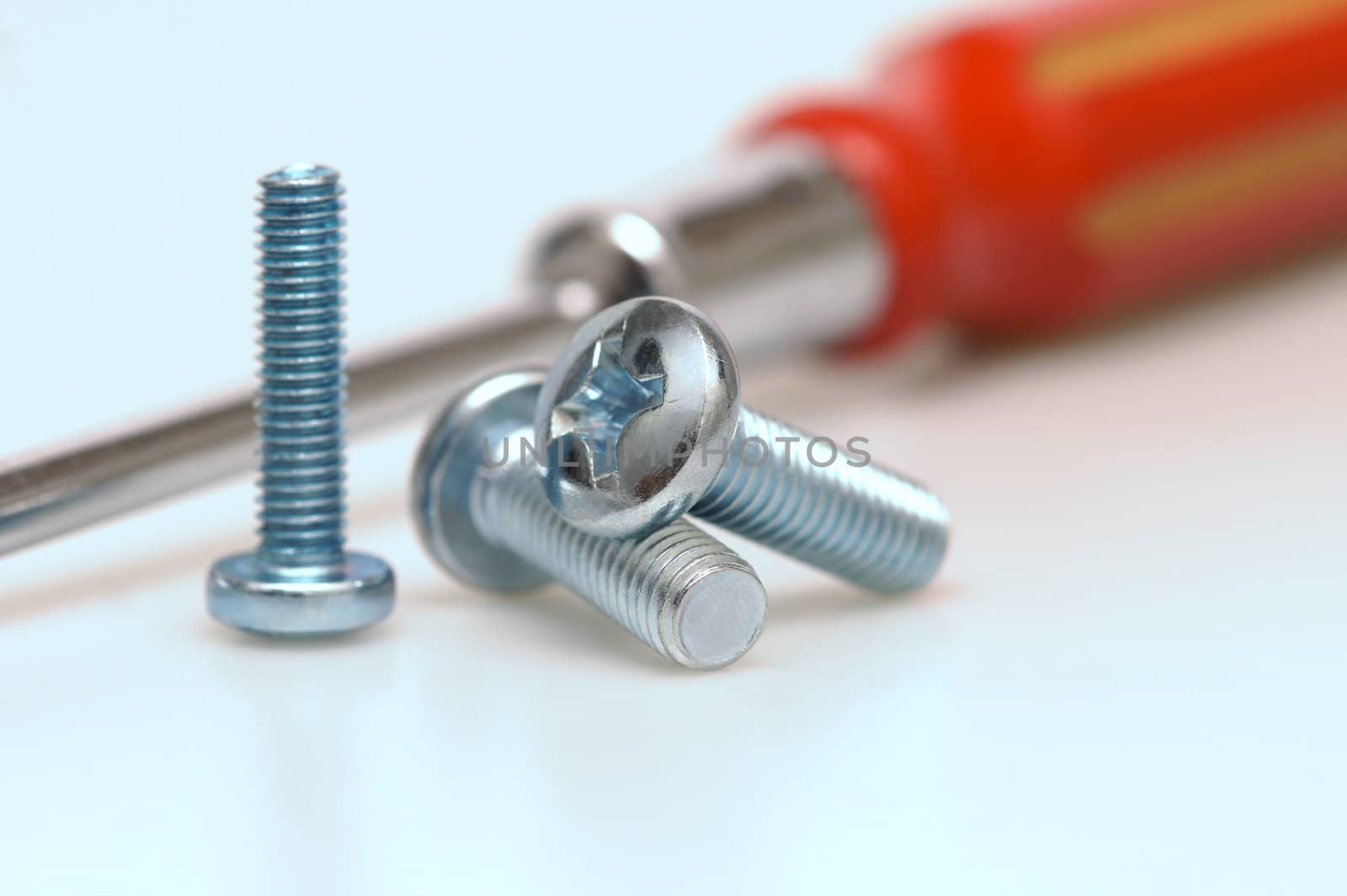 Great plan of three screws with a screwdriver background. shallow depth of field.