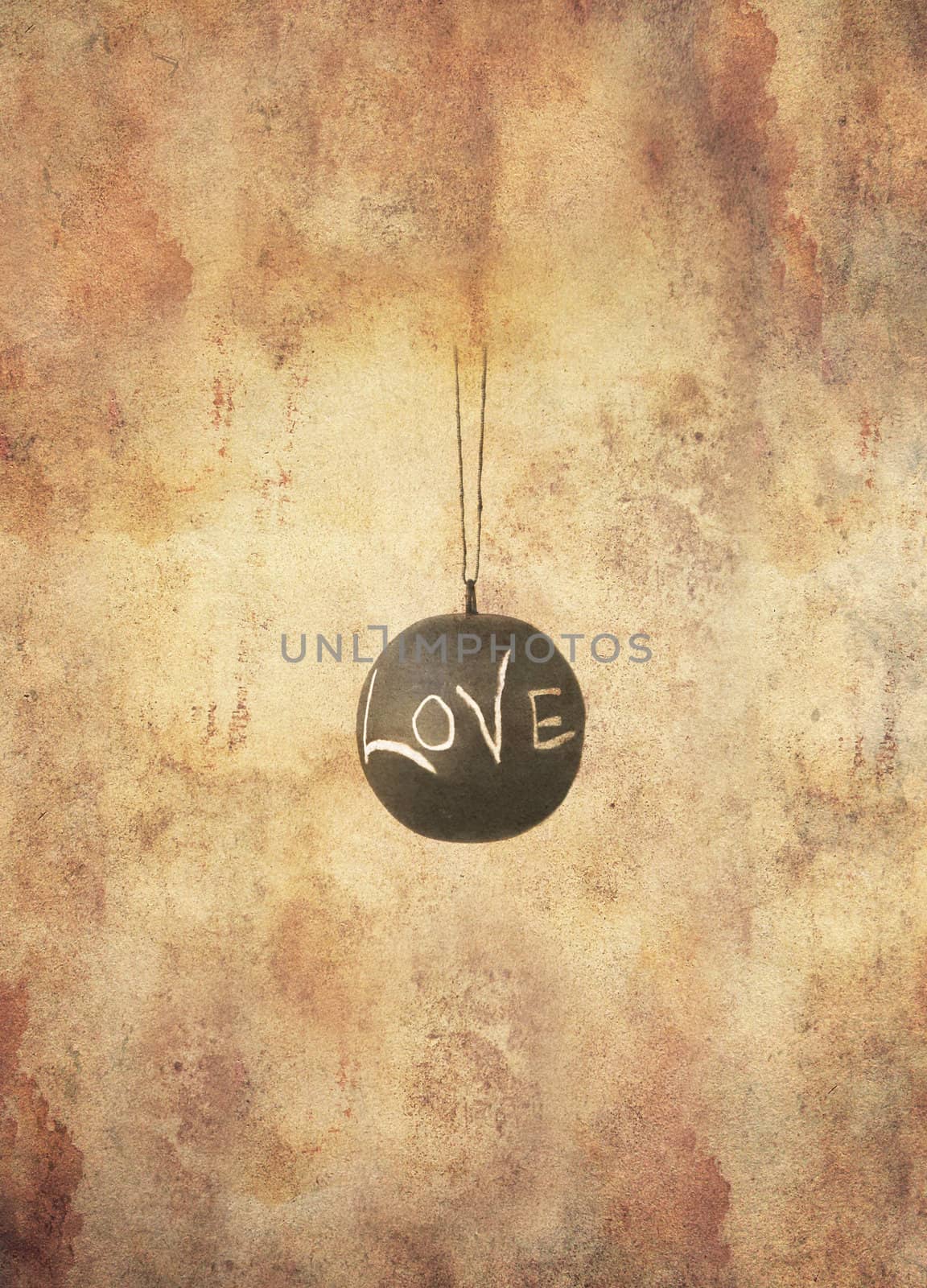 One single slate ball with the message love written by hand in chalk hanging freely, in grunge style.