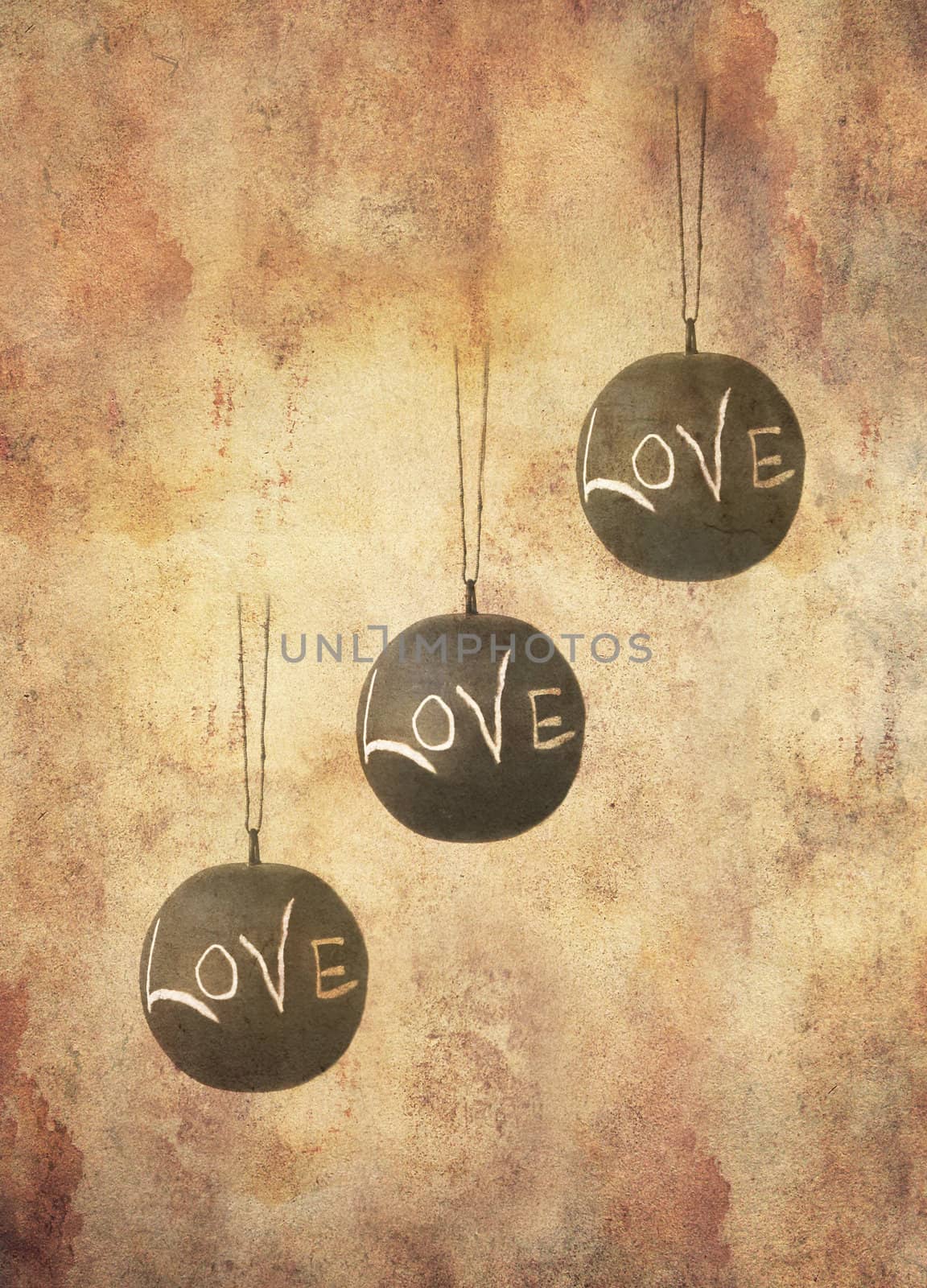 Three slate balls with the message love written by hand in chalk hanging freely, in grunge style.
