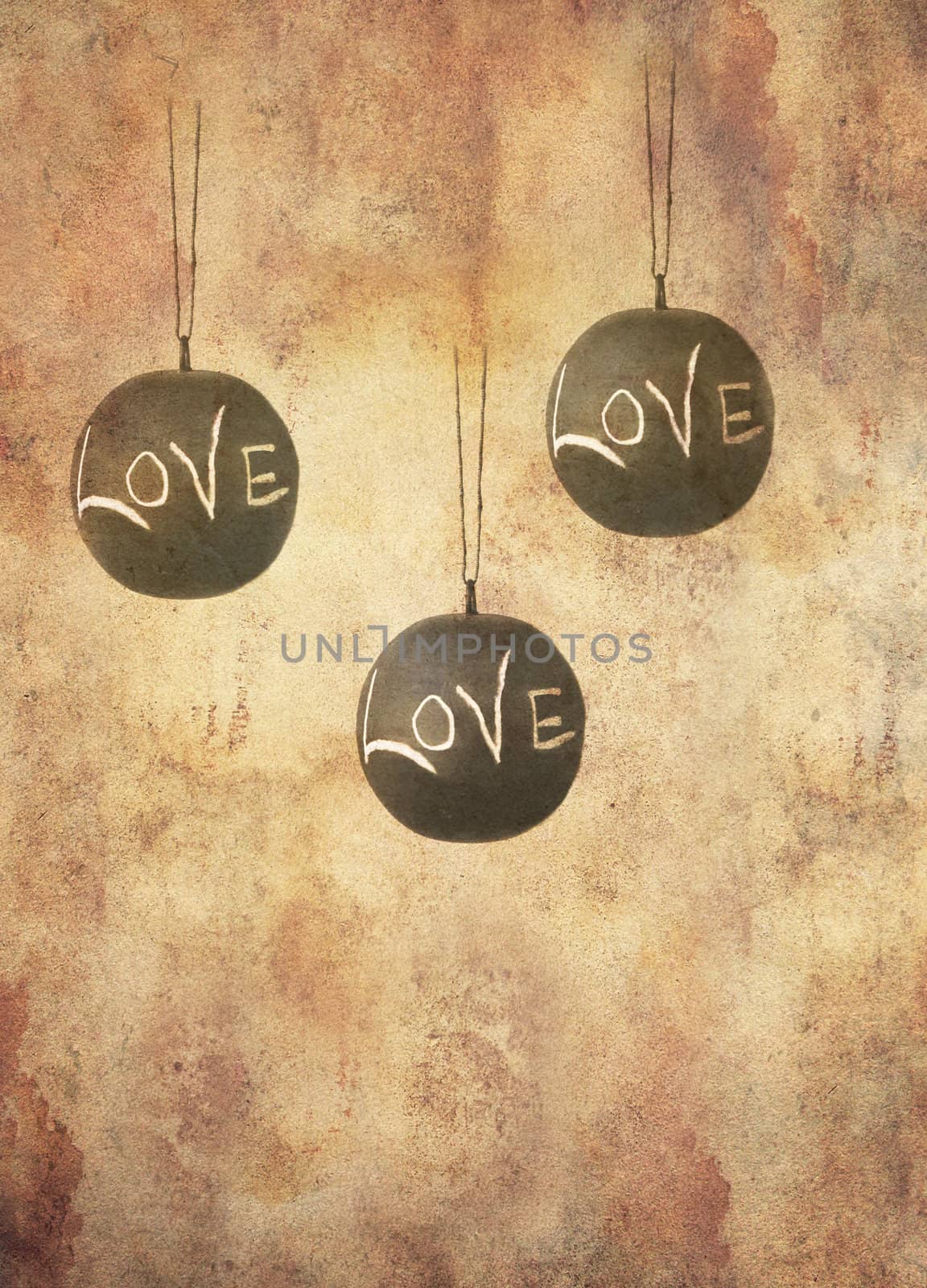 Three slate balls with the message love written by hand in chalk hanging freely, in grunge style.