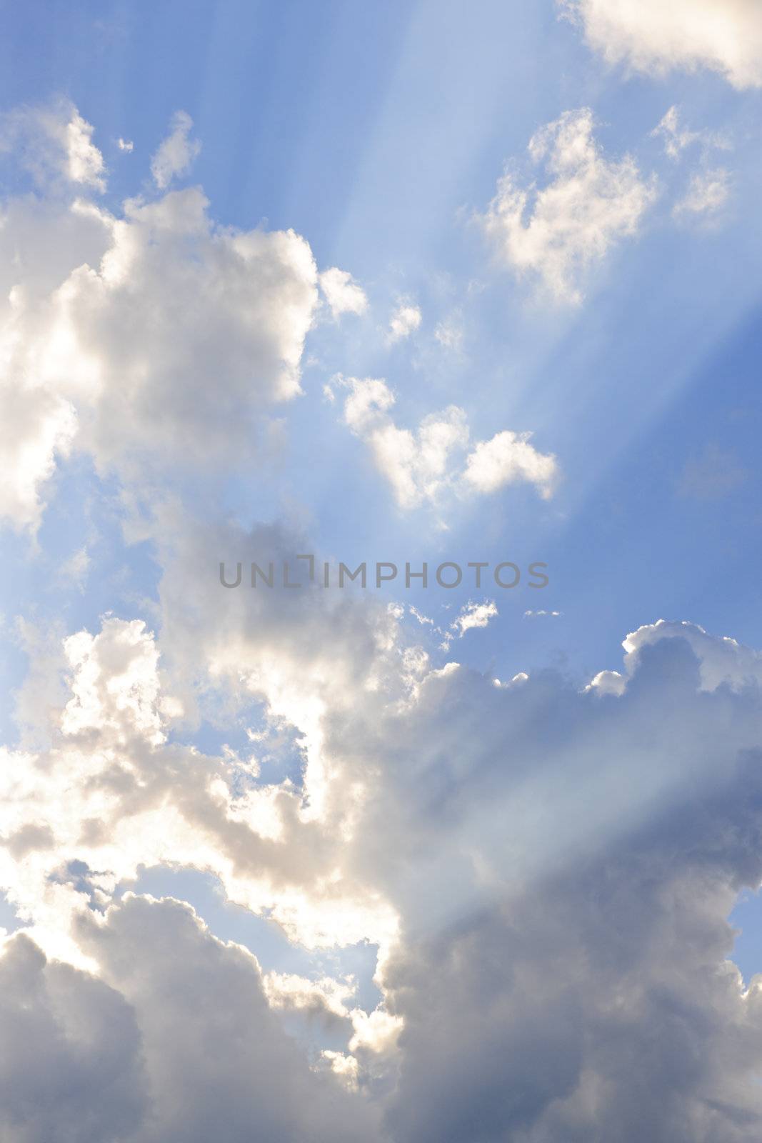 Background of blue sky with sun rays and clouds