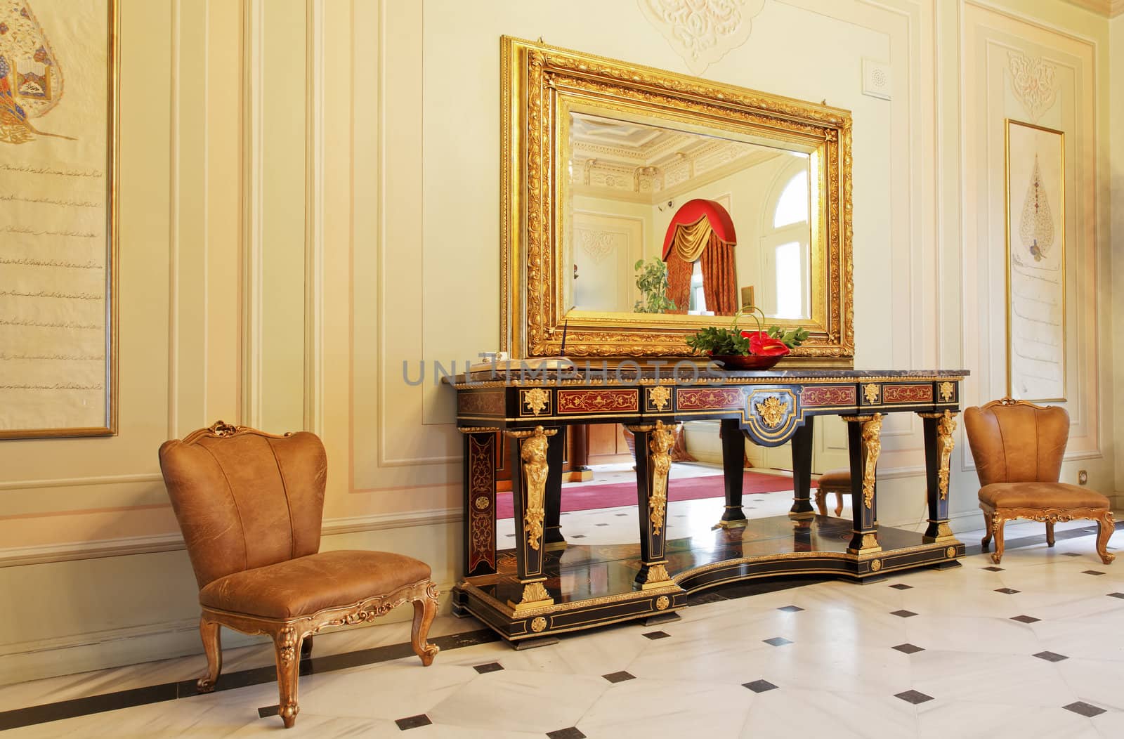 Bosphorus Palace Hallway, Istanbul, Turkey - July 2, 2011: Elegant Ottoman style of furniture and interior decorations with paneled walls, visitors chairs, large mirror, side table and tiled flooring