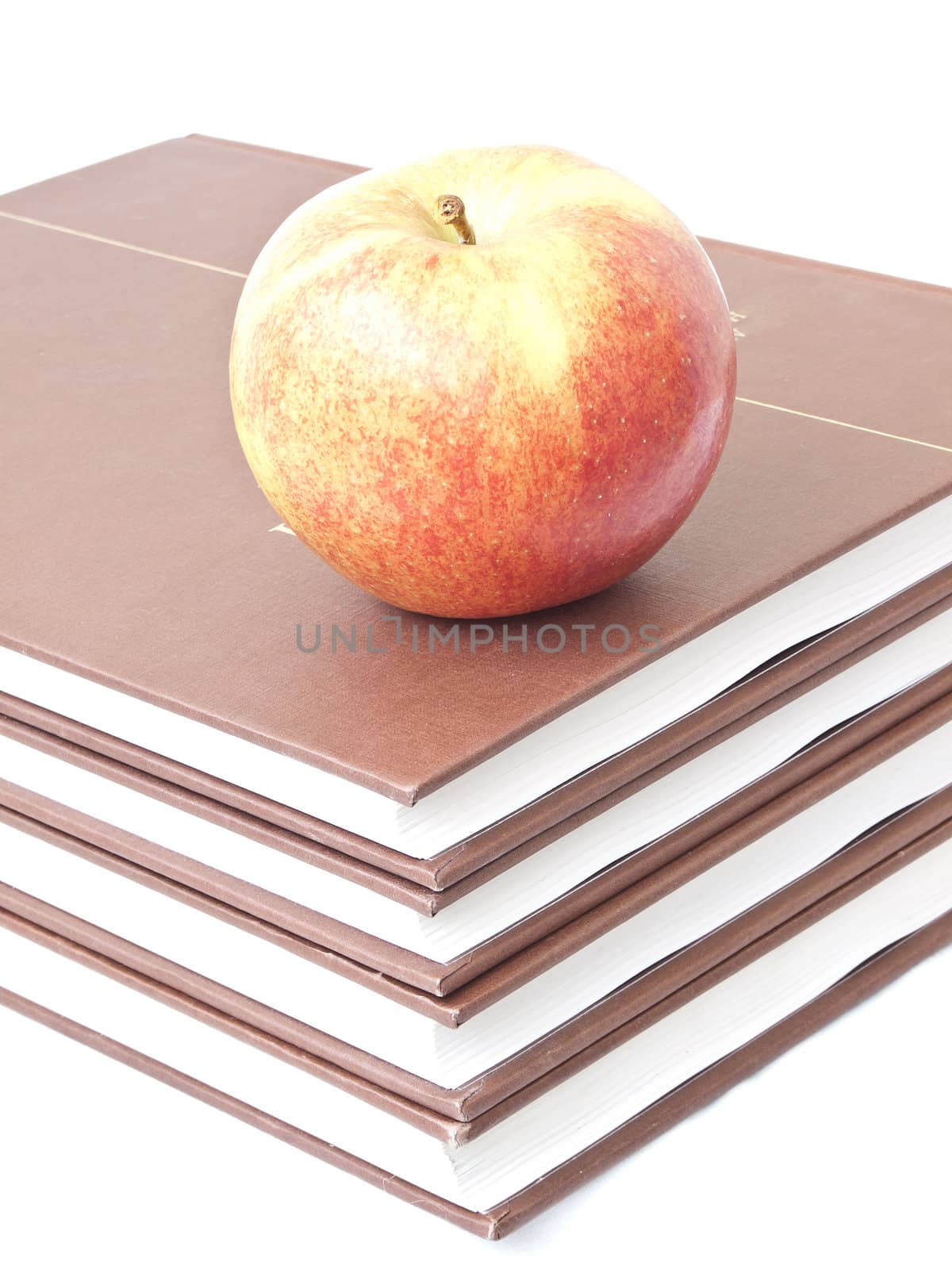 Isolated apple on a stack of four books