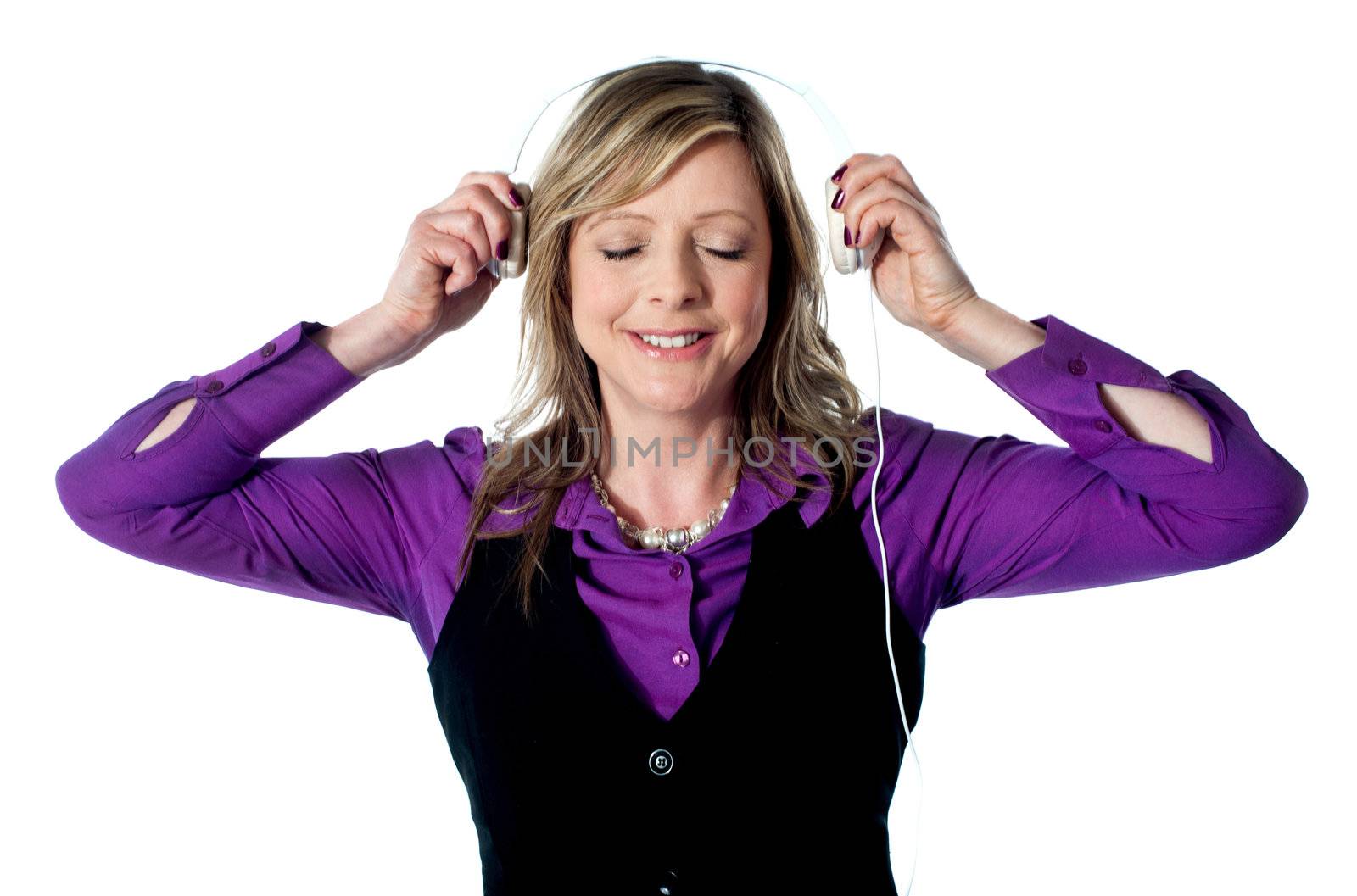 Lady enjoying music through headphones, eyes closed and smiling