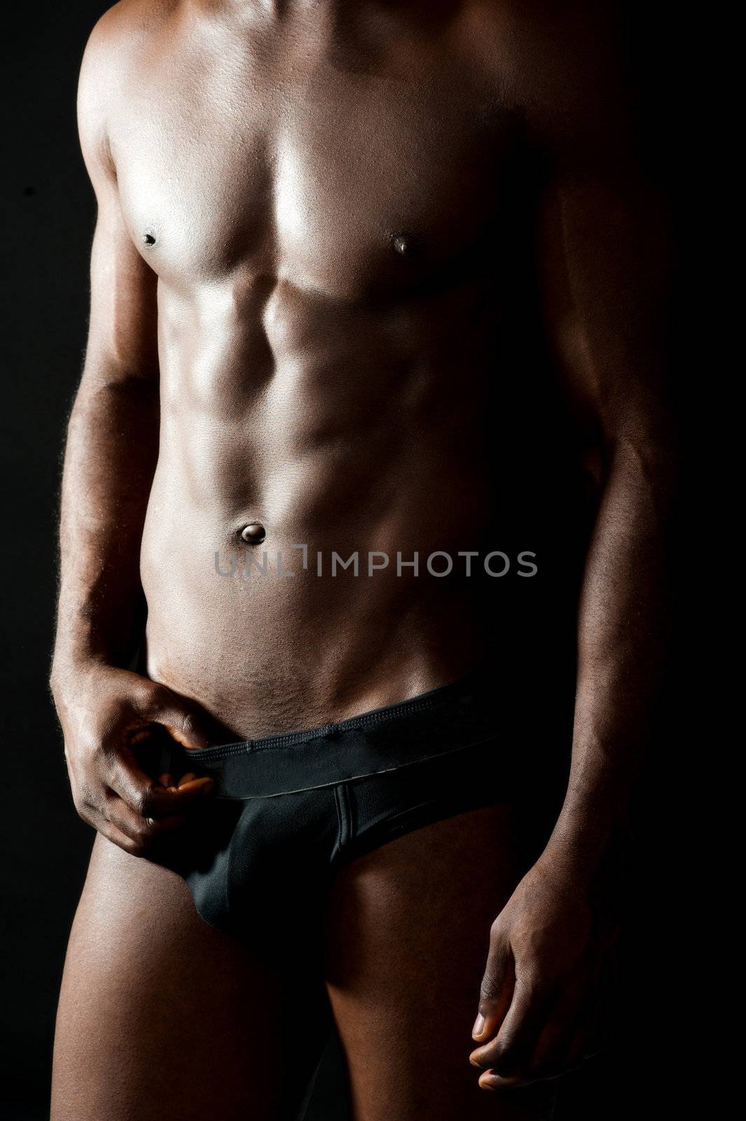 Naked torso of young muscular man by stockyimages