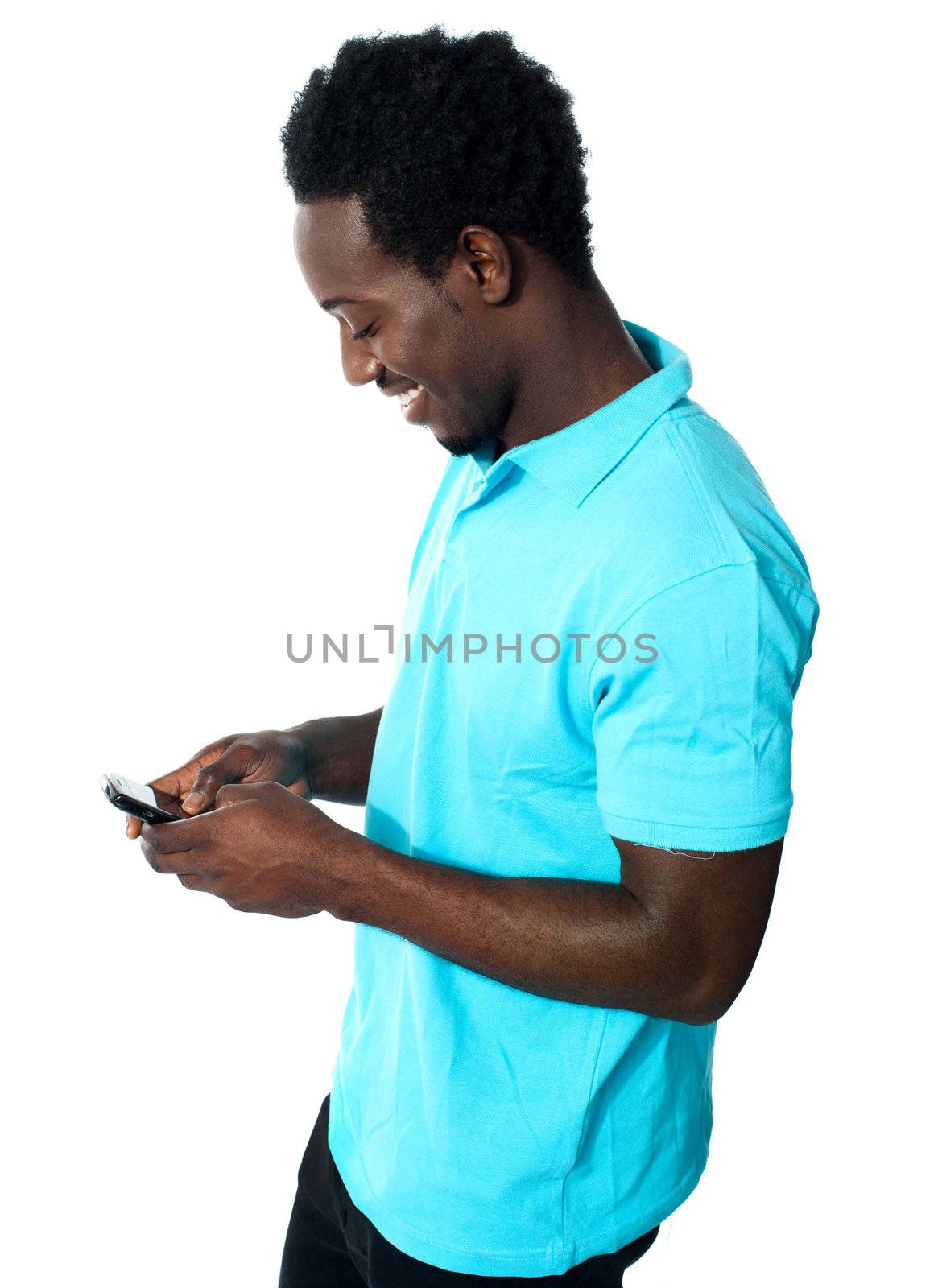 African boy busy messaging and smiling while reading message