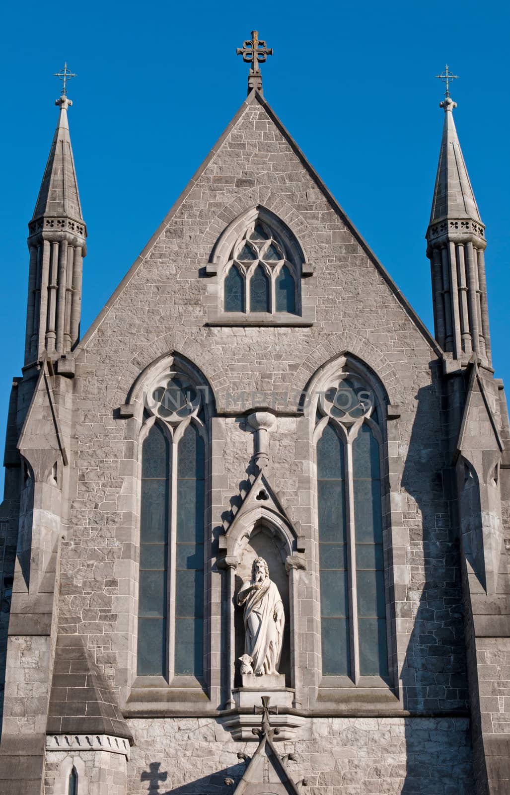 entrance detail with marble statue at Saint John's cathedral in Limerick, Ireland (blue sky background)