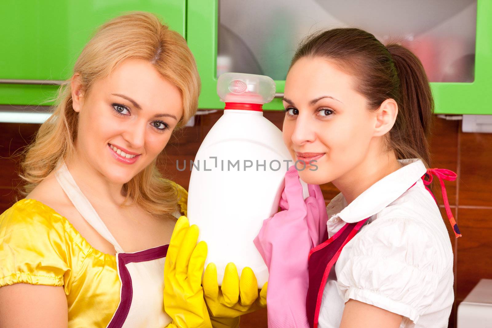 Two young attractive women clean the kitchen