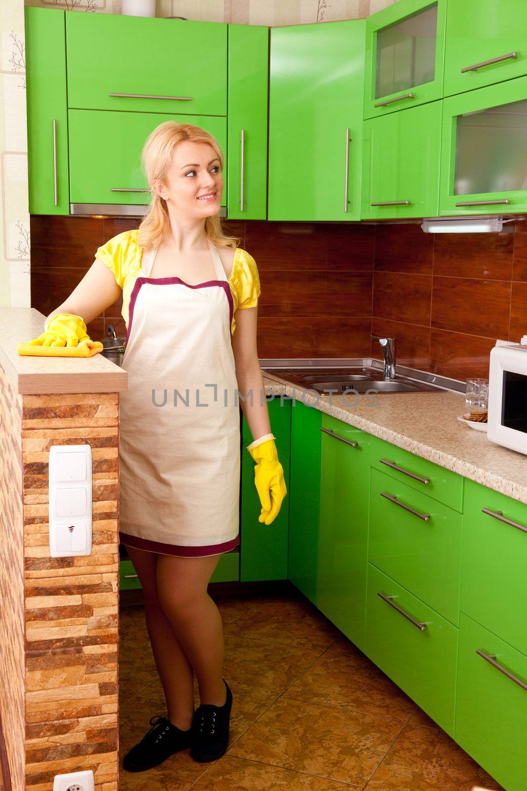 young attractive woman clean the kitchen ( green color )