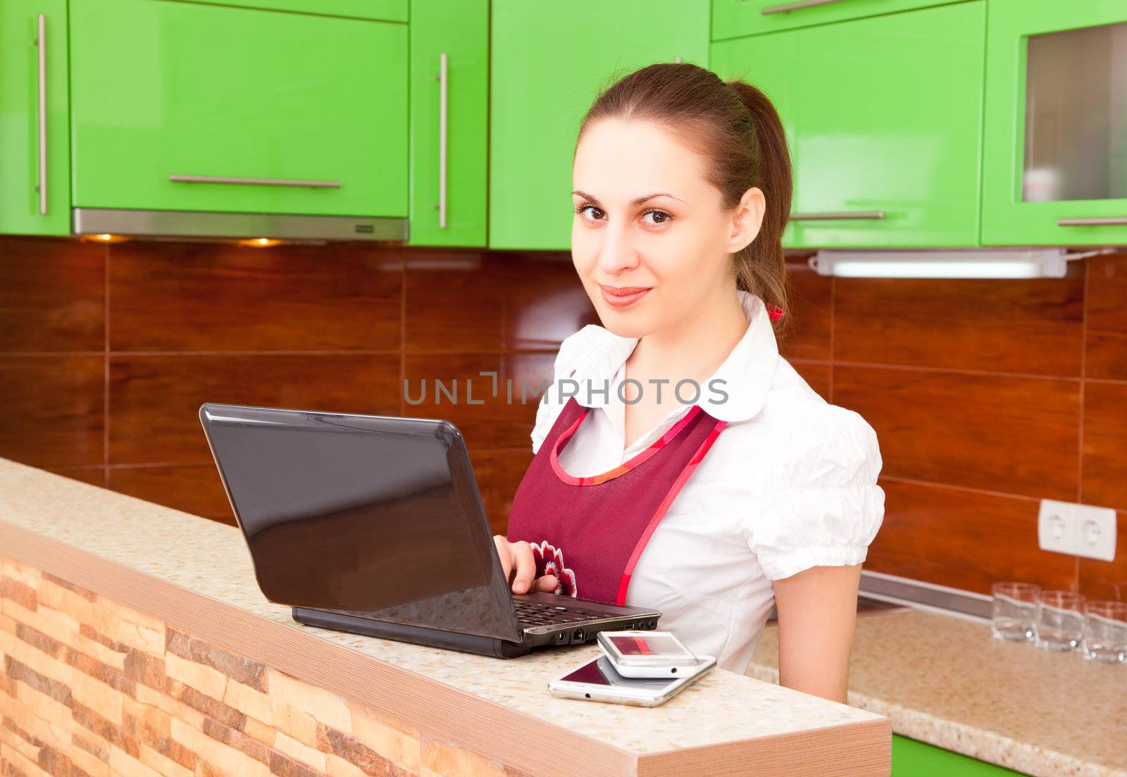 young woman with a laptop in the kitchen