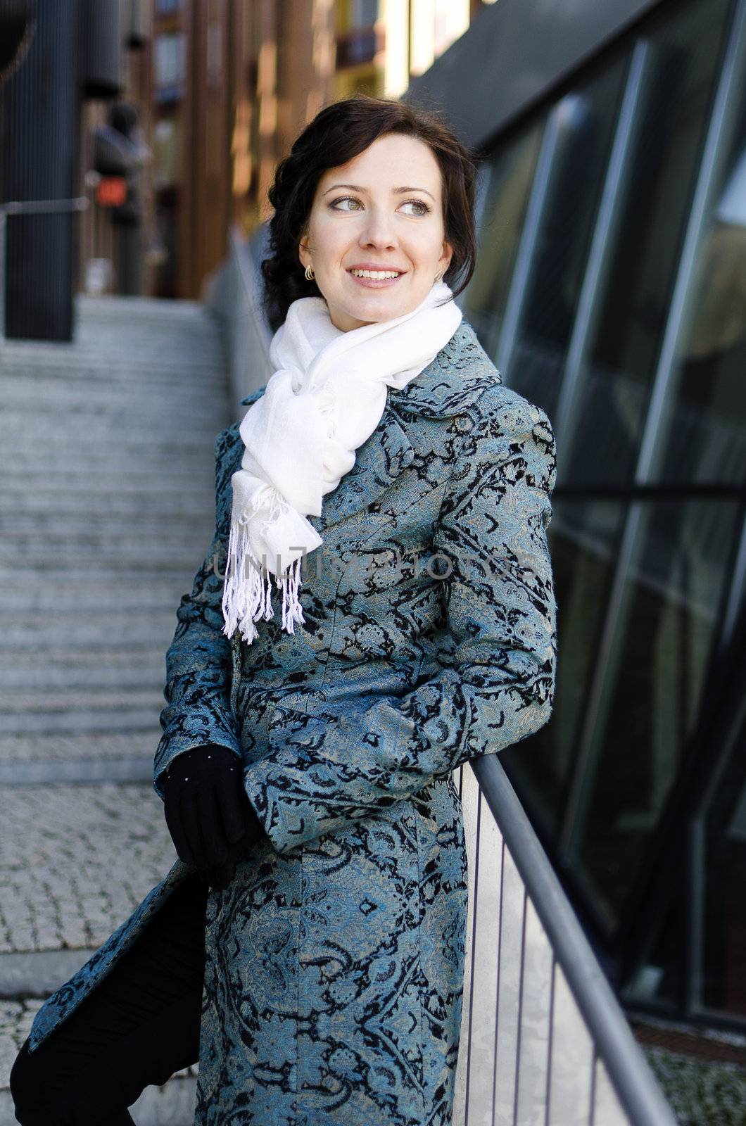 Portrait of a smiling pretty girl with a scarf on the street