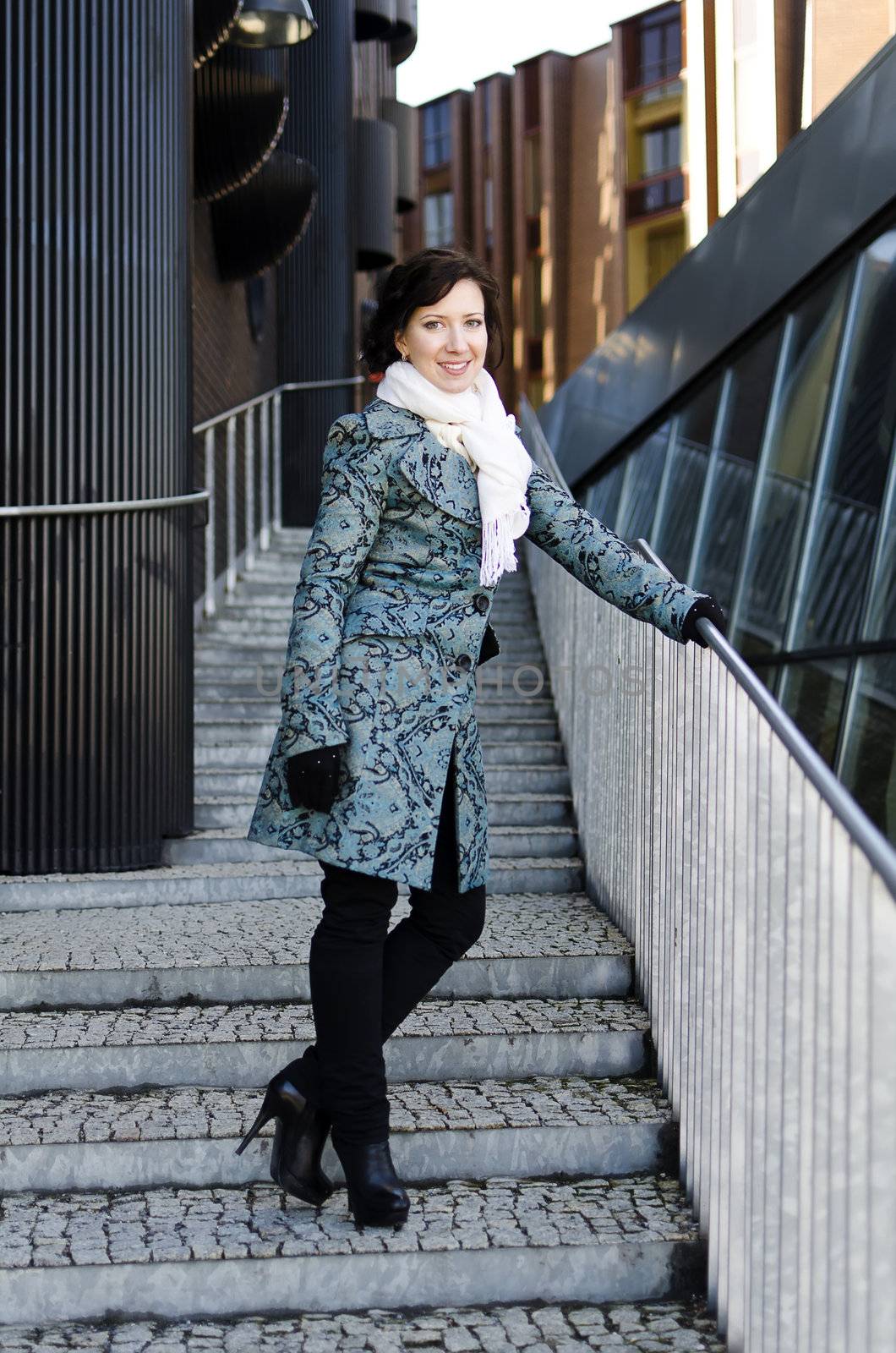 Portrait of a smiling pretty girl with a scarf on the street