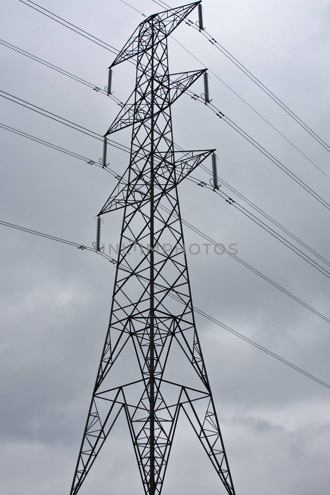 An electricity pylon against a dark cloudy sky