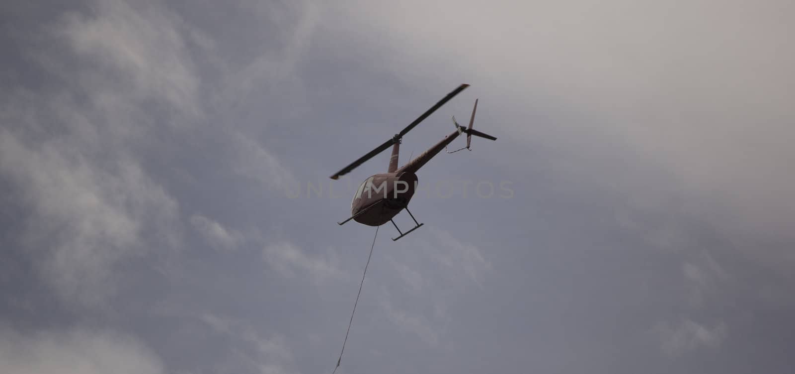 Helicoptor with a water bucket fighting fire