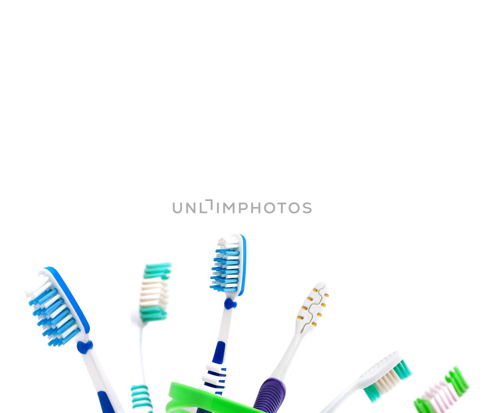 Colorfull toothbrushes in a cup isolated on white background