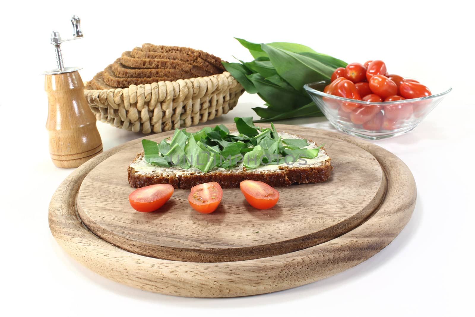 ramson bread with butter, fresh ramson and tomatoes on a light background