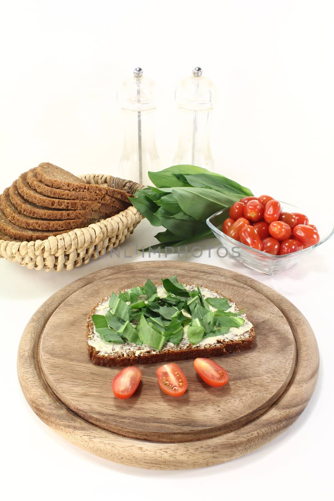 fresh ramson bread with butter, ramson and tomatoes on a light background