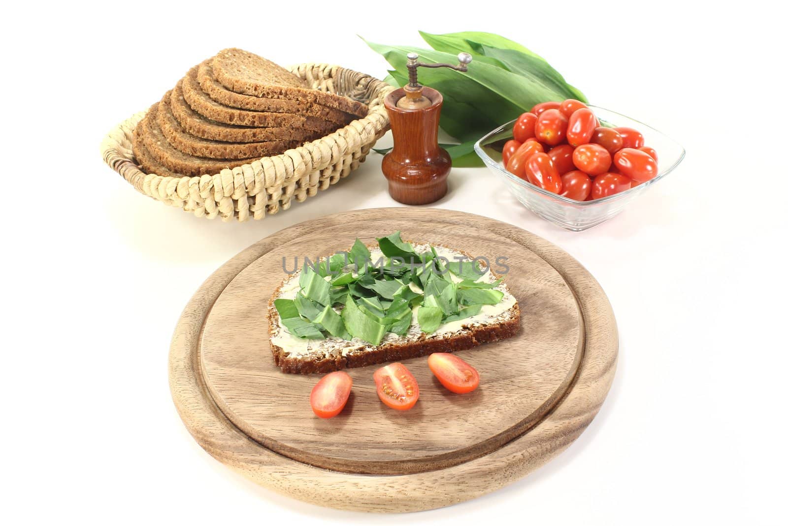 fresh bread with butter, ramson and tomatoes on a light background