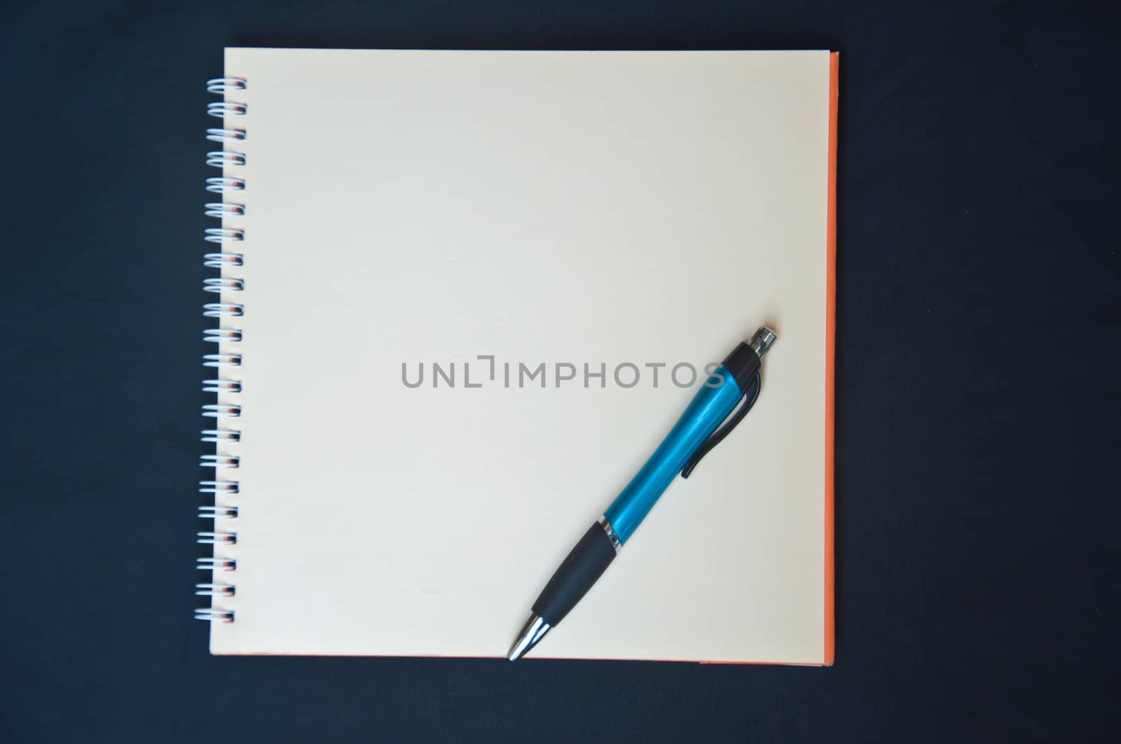 pen and notebook on black background