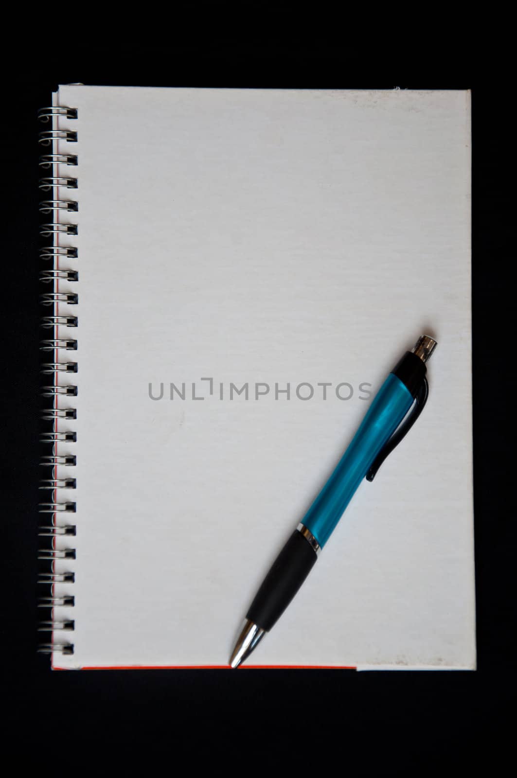 pen and notebook on black background