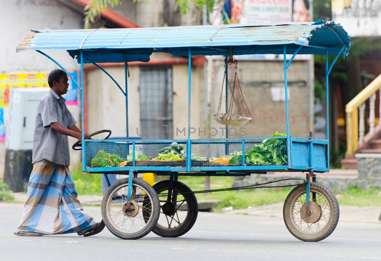 Colombo, Sri Lanka - December 14, 2011: Traditional Asian small street trader with his mobile stall of vegetables