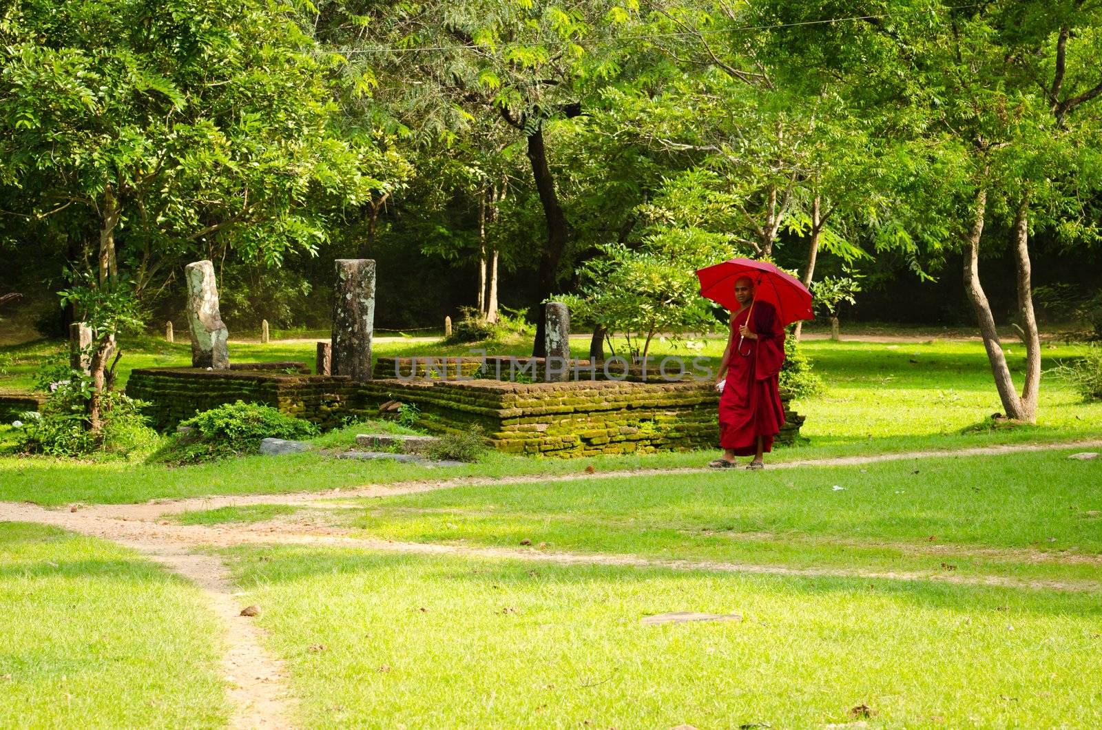 Buddhism monk in red clothes follows the path by iryna_rasko