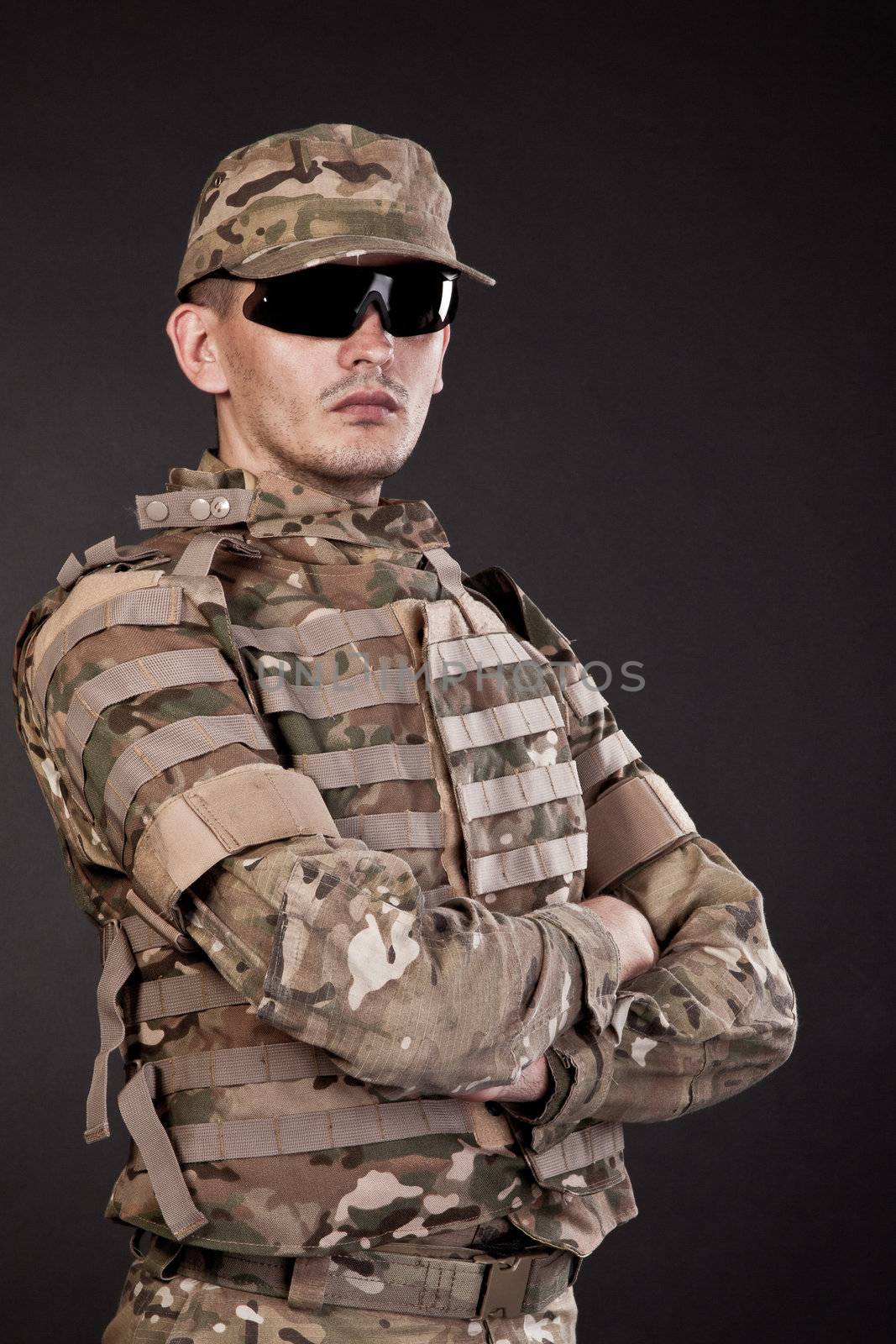Half length photogaph portrait of adult man in his US Army uniform; copy space on black background