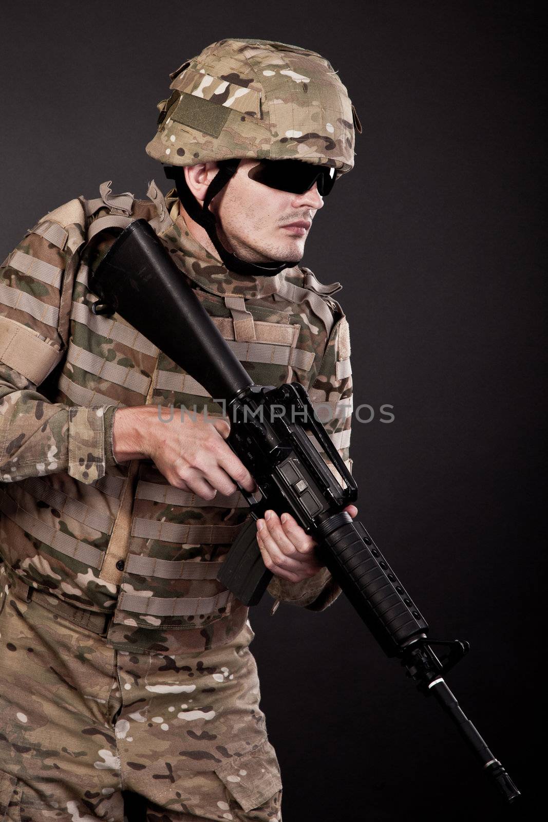 Modern soldier with rifle isolated on a black background