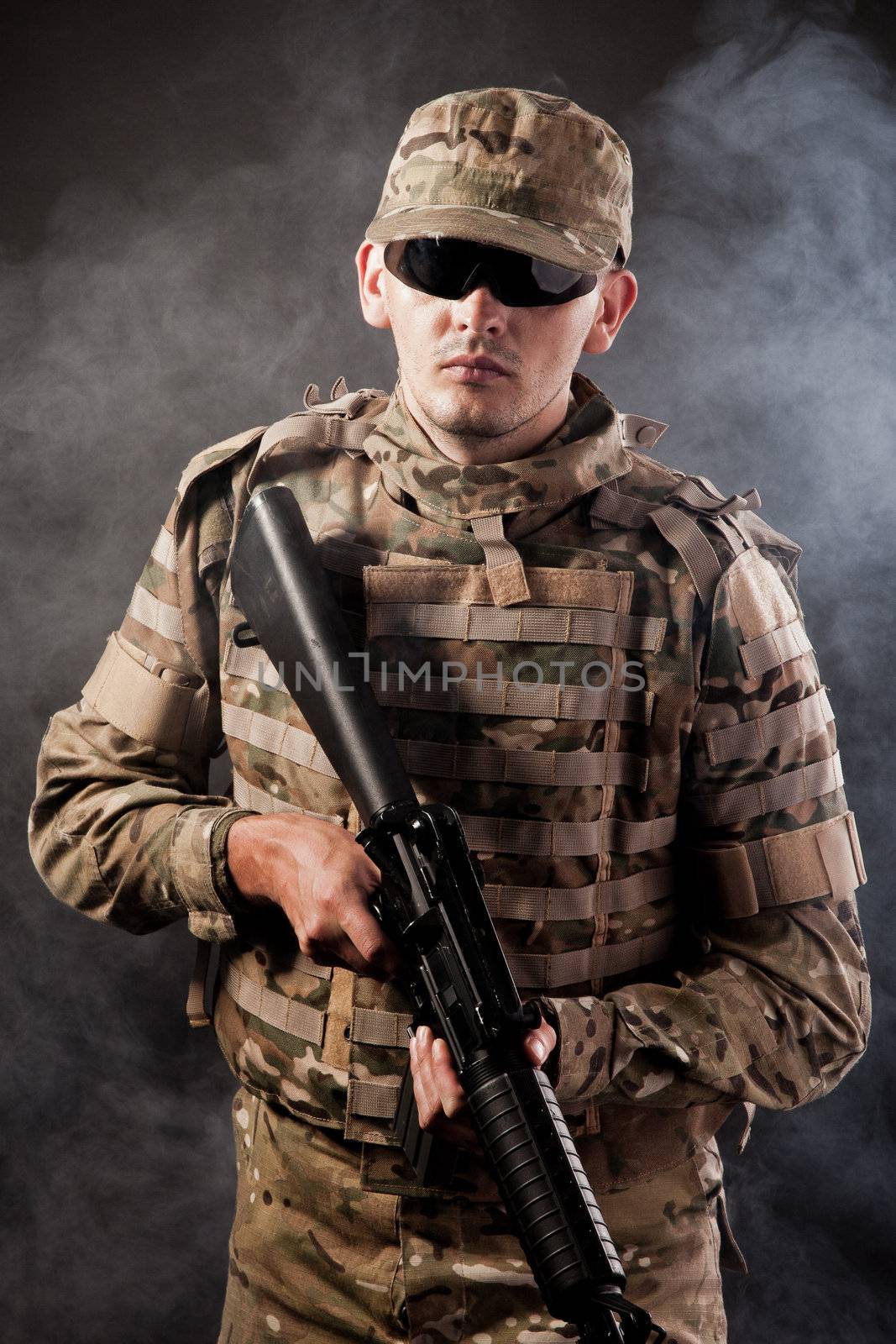 Modern soldier with rifle isolated on a black background