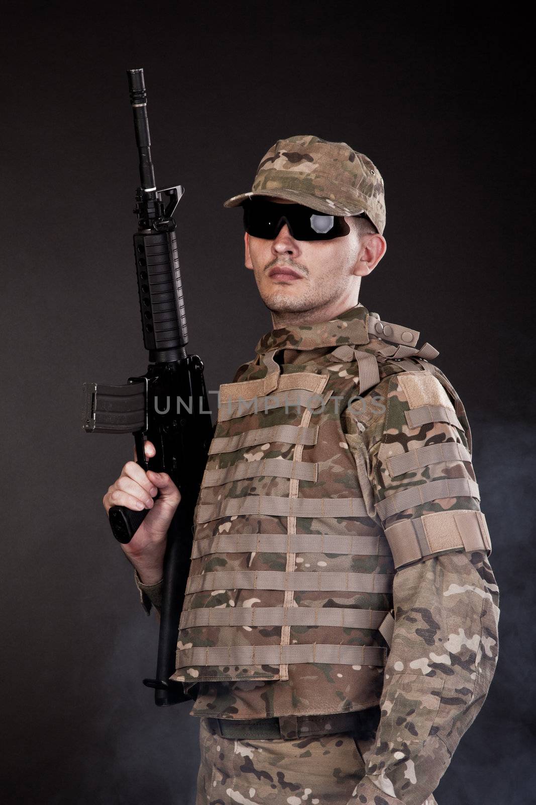 Modern soldier with rifle isolated on a black background
