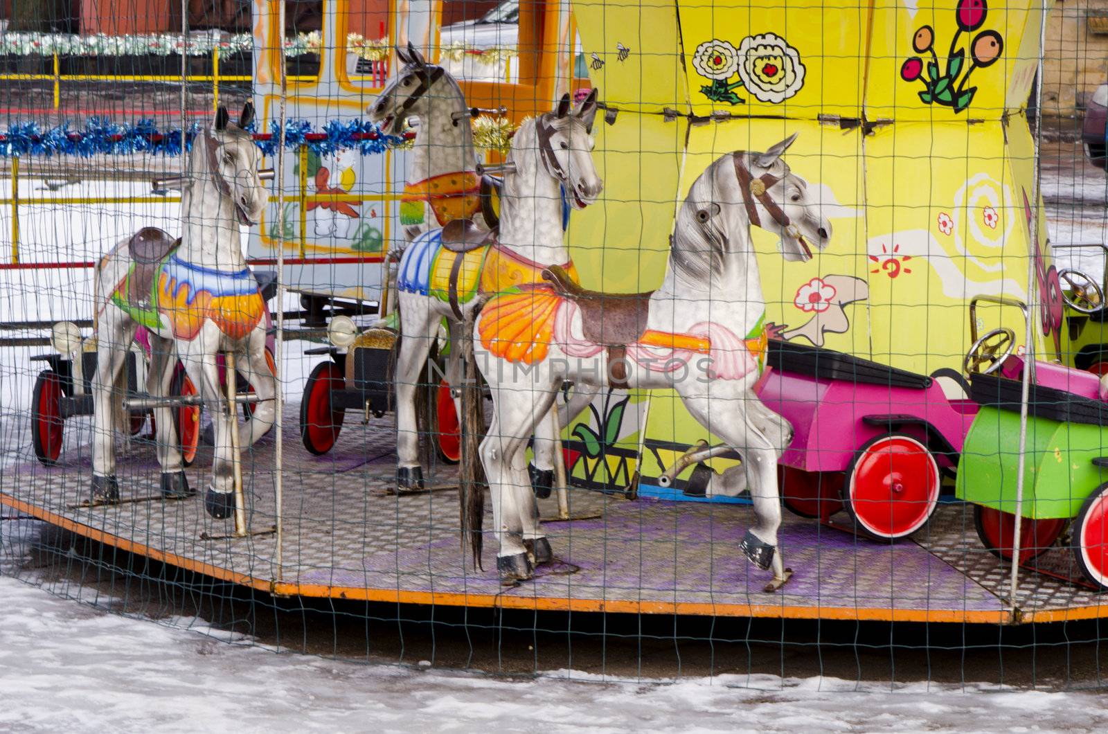 Amusement park carousel entertainment colorful cars and horses.