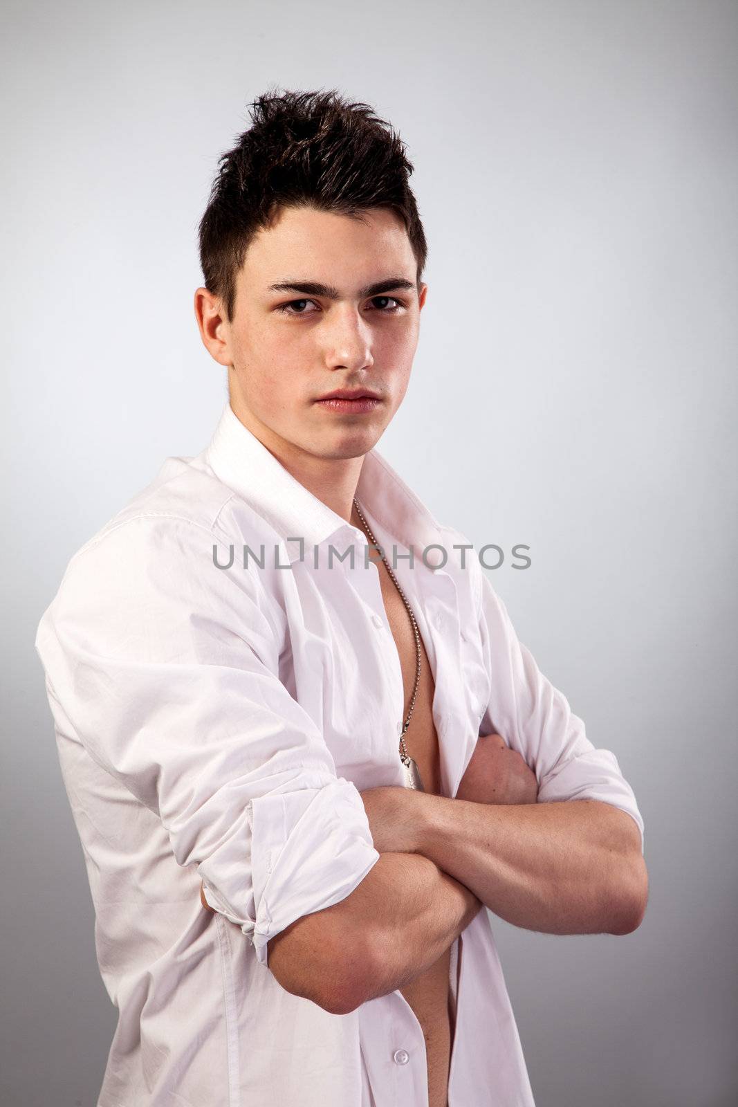 Healthy muscular young man. Isolated on grey background.