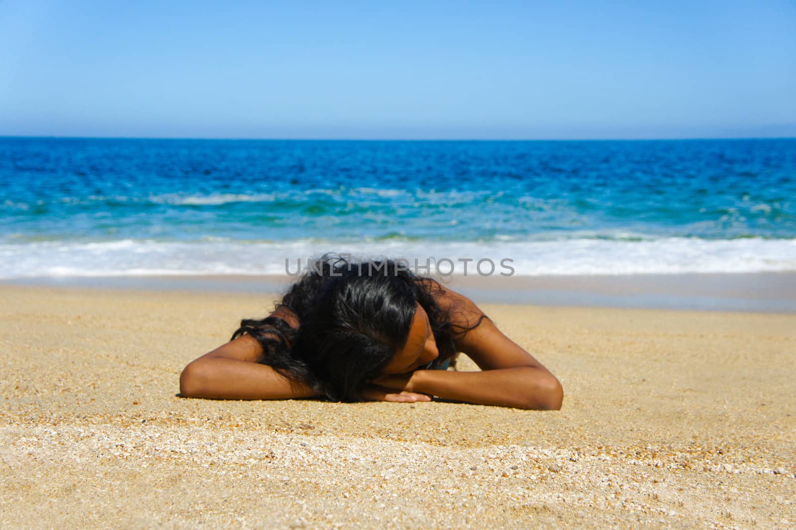 Young woman lying  on beach sun tanning.