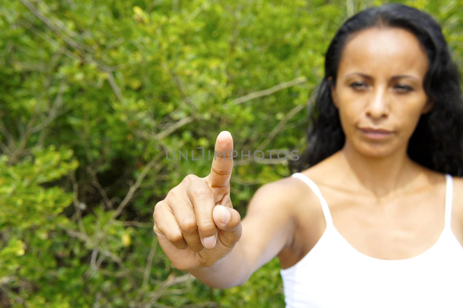 Young latin woman pointing with a finger in the air. 
