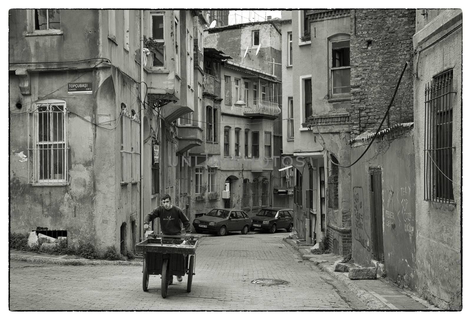 HARD WORKING BUSINESSMAN, ISTANBUL, TURKEY, APRIL 17, 2012: Young mang with a push handcart collecting scrap for recycling in the old Fatih district of Istanbul, Turkey.