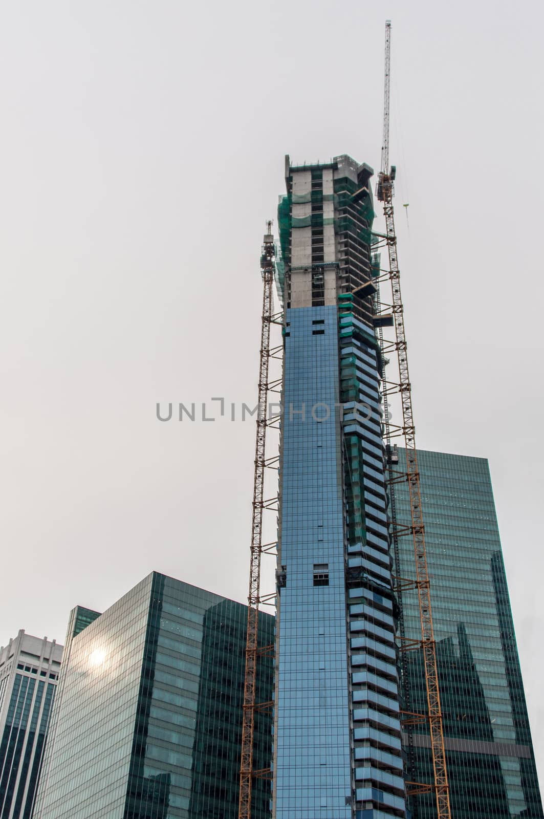 High rise construction site with crane in downtown Singapore
