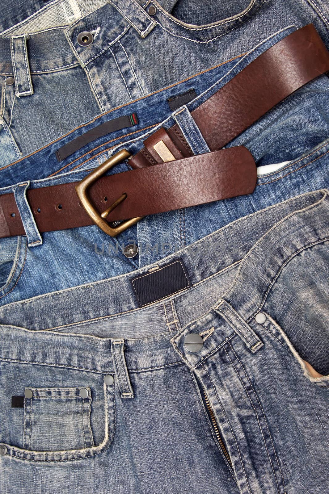 Three pairs of jeans pants and a belt