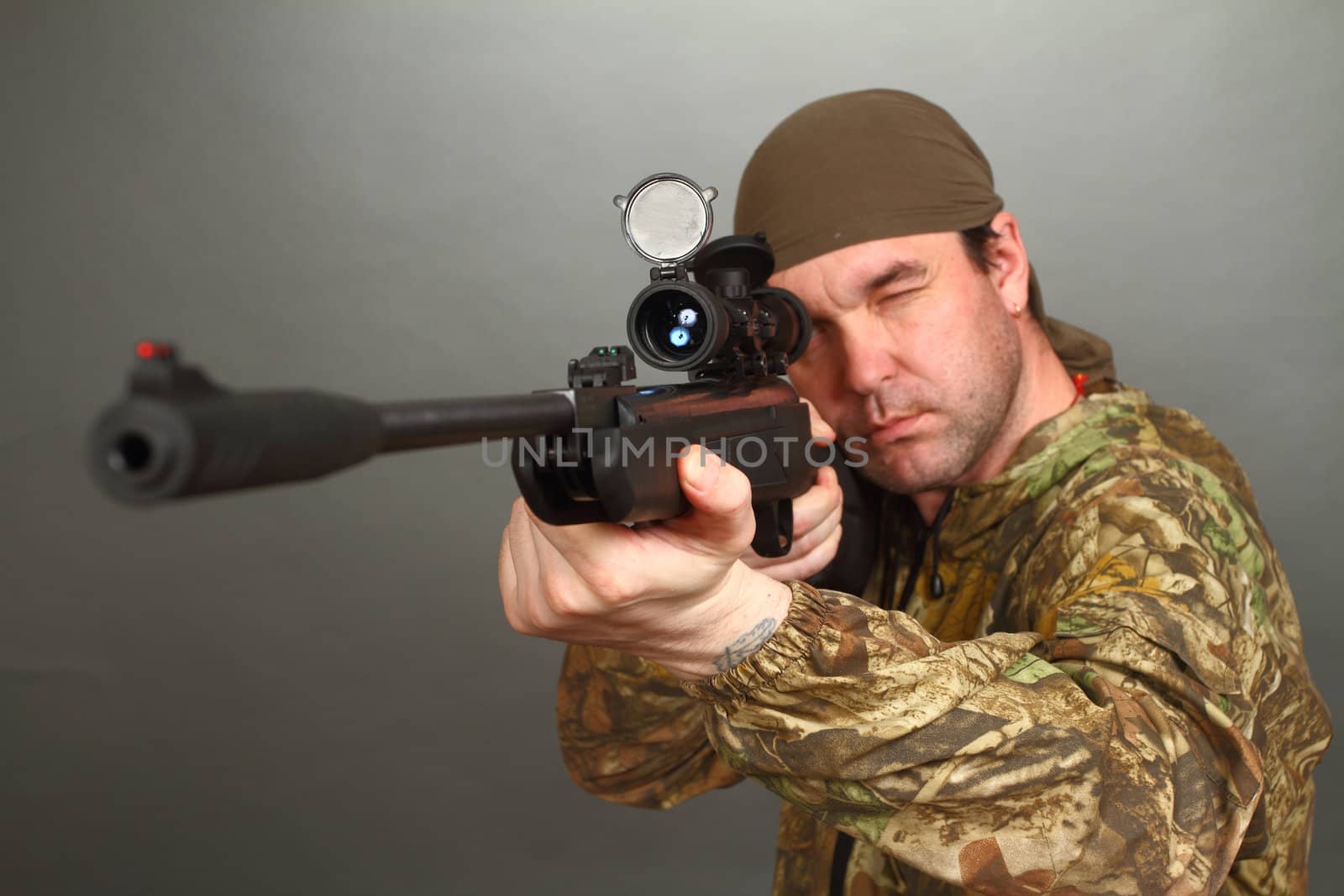 the man in a camouflage aims from a rifle with a riflescope. double 6