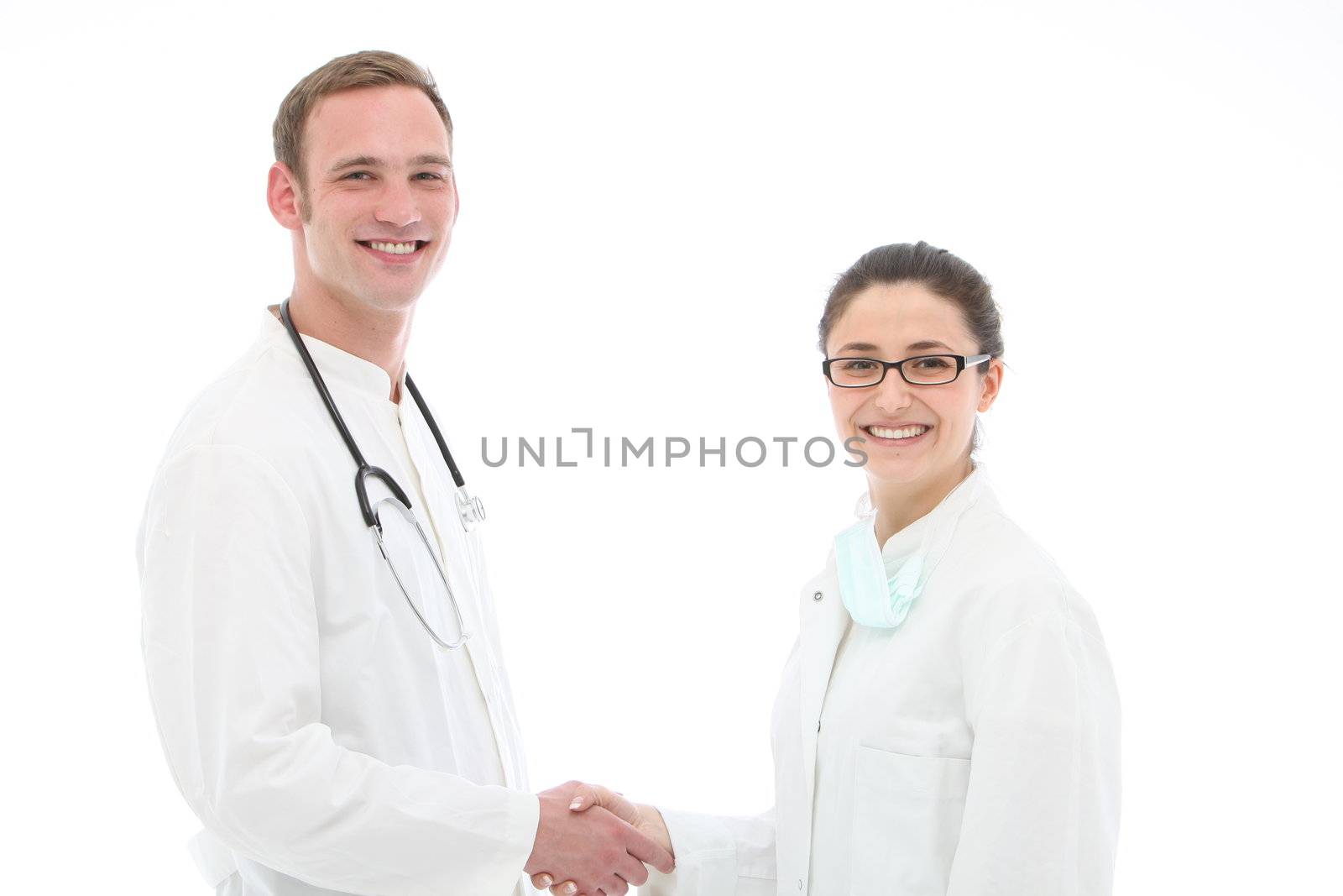 Smiling young male doctor congratulating his assistant or nurse on a successful outcome as a medical team