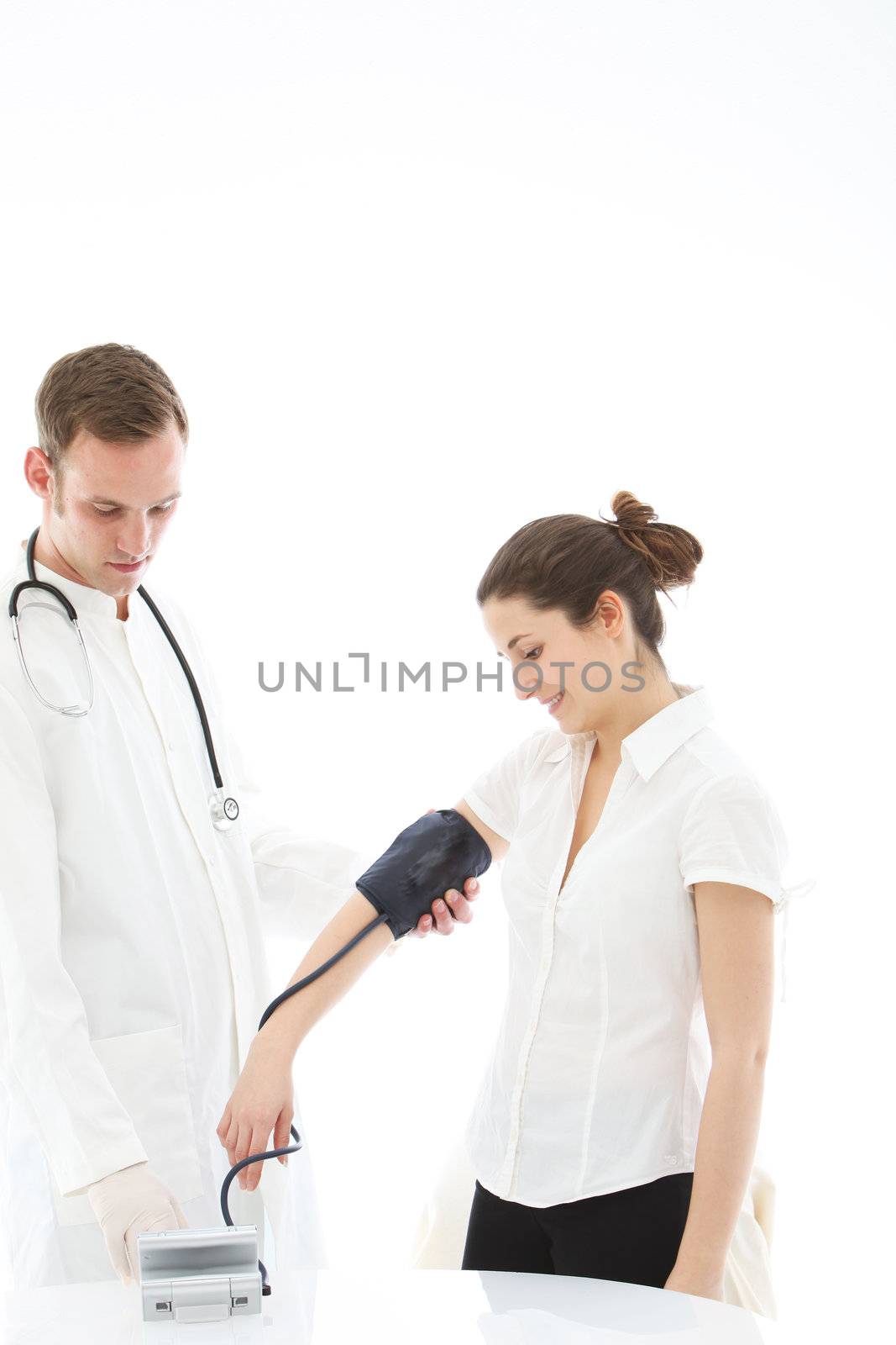 Doctor taking the blood pressure reading of a female patient using a sphygmomanometer