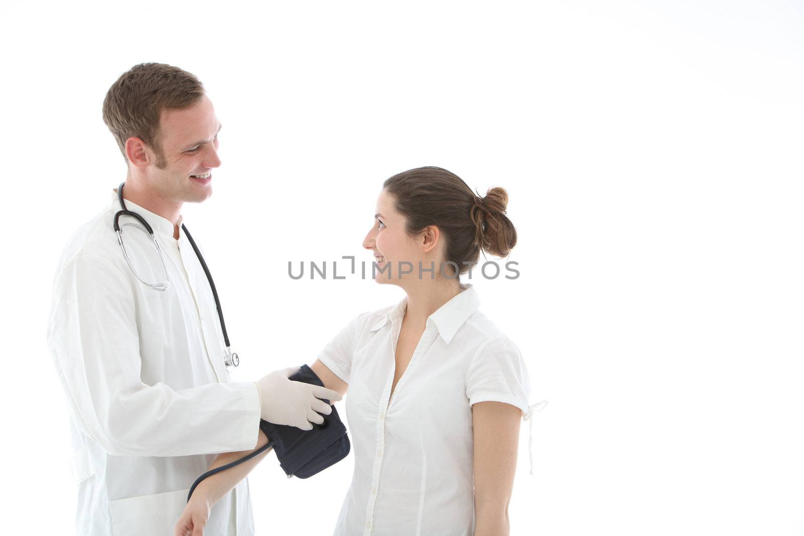 Smiling doctor applying the pressure cuff of a sphygmomanometer to take a blood pressure reading