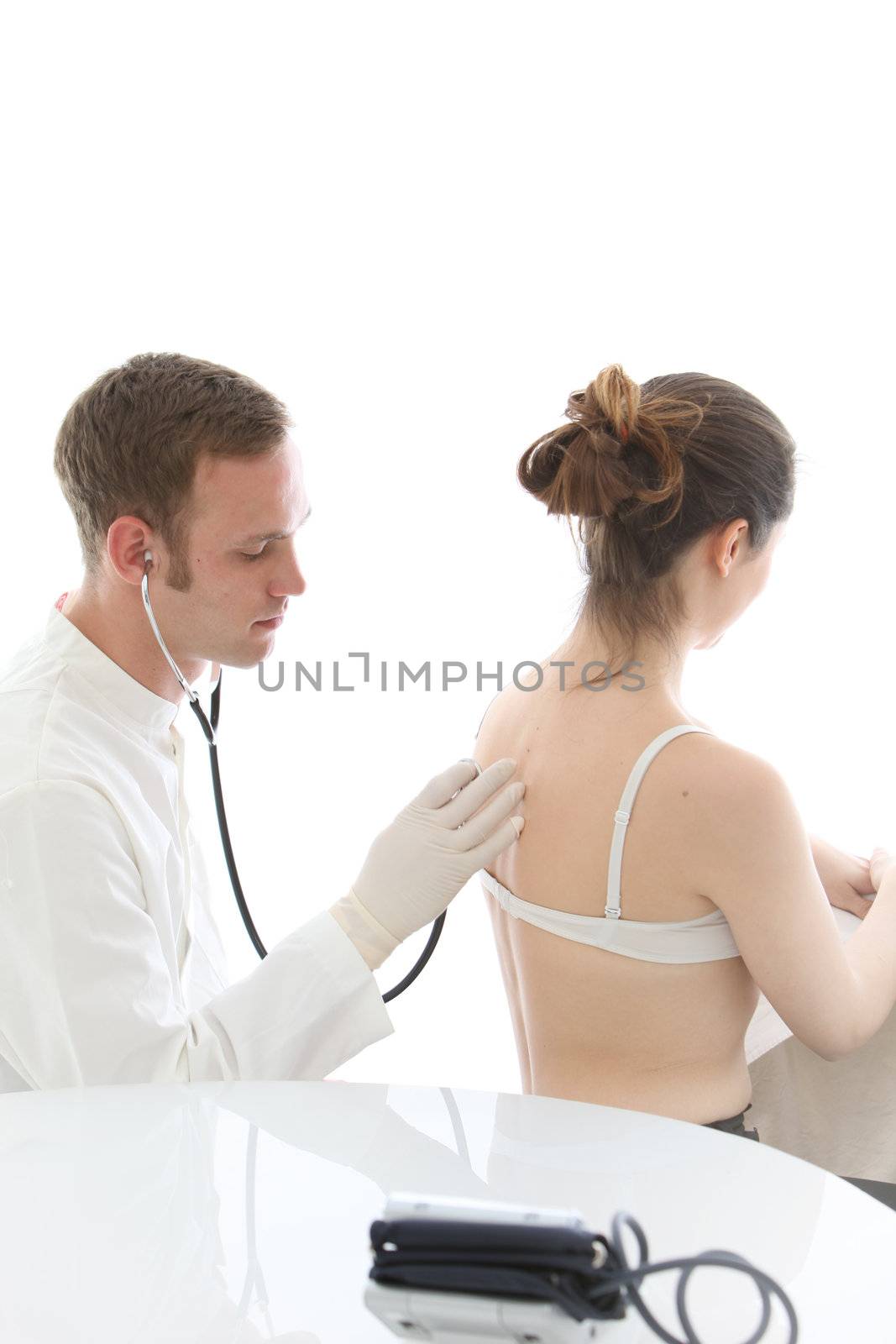 Doctor listening to a woman's lungs and breathing with a stethoscope during an examination