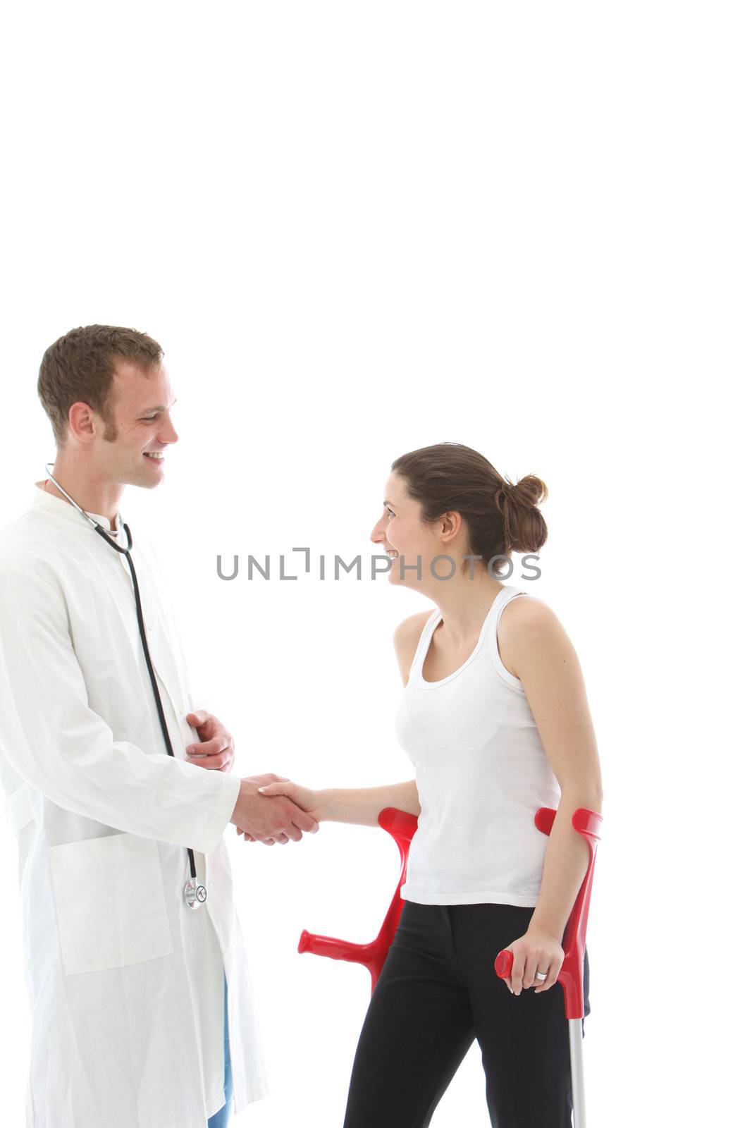 Grateful young disabled woman patient on crutches thanking her doctor by shaking his hand