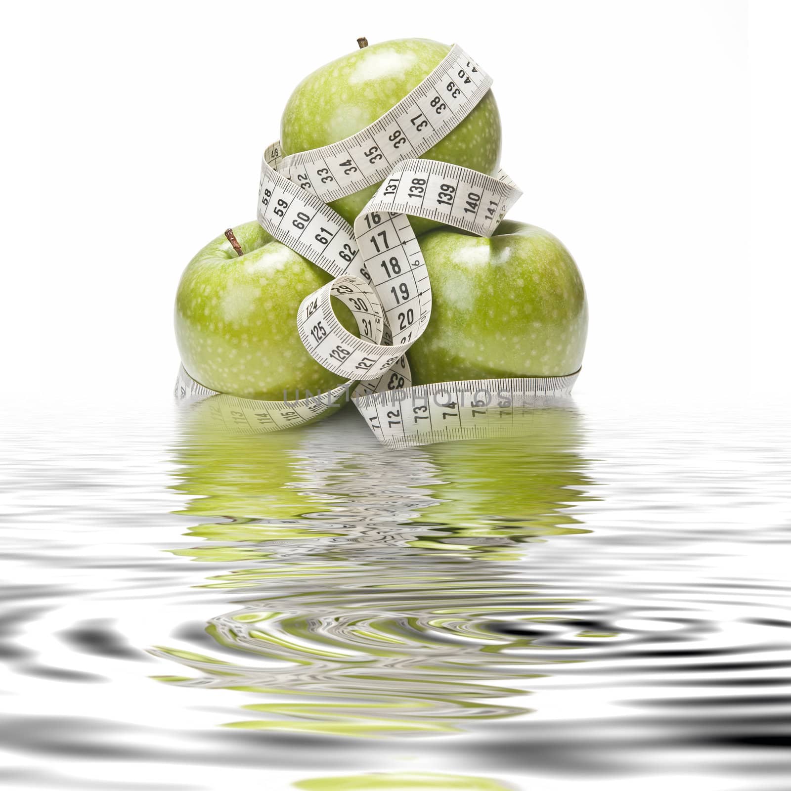 Measuring tape wrapped around a green apple as a symbol of diet.