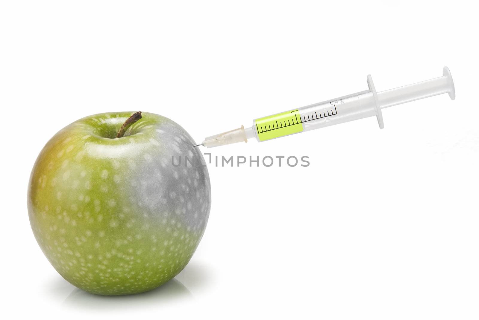 A syringe inserted  in an apple on a white background.