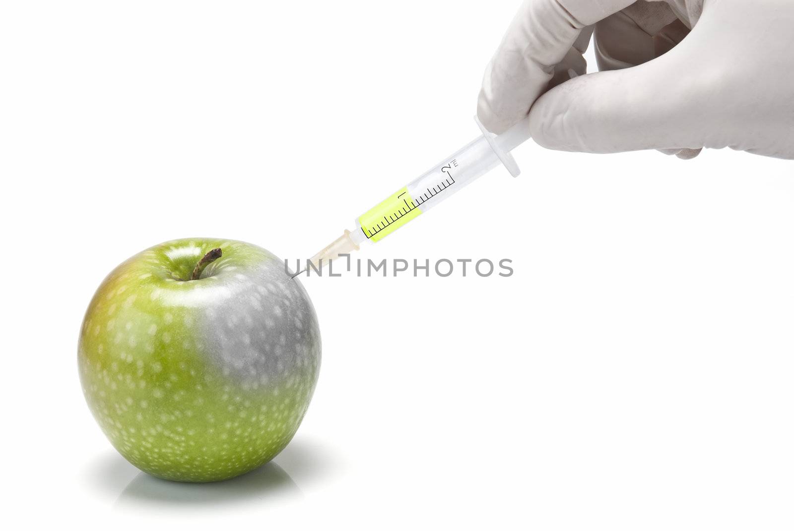 A gloved hand injecting an apple with a syringe on a white background.